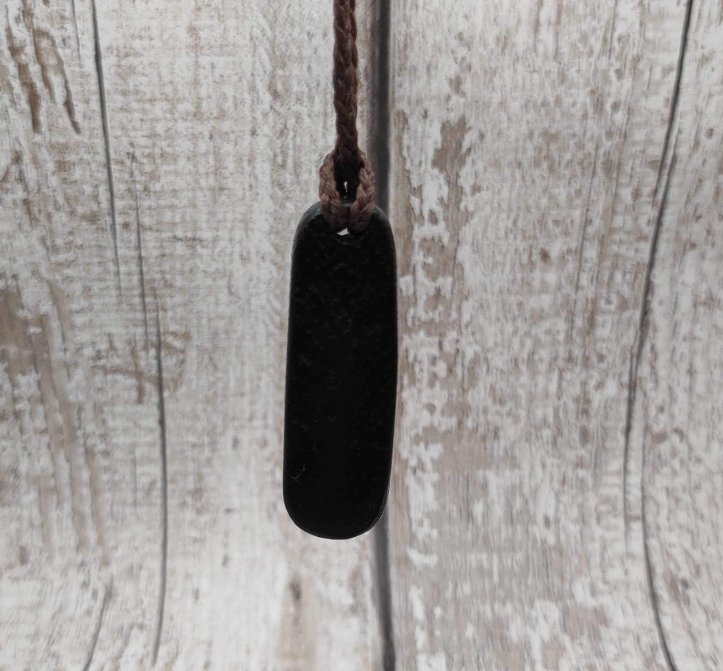 Bog oak hand carved pendant with a moldavite dot inlay.