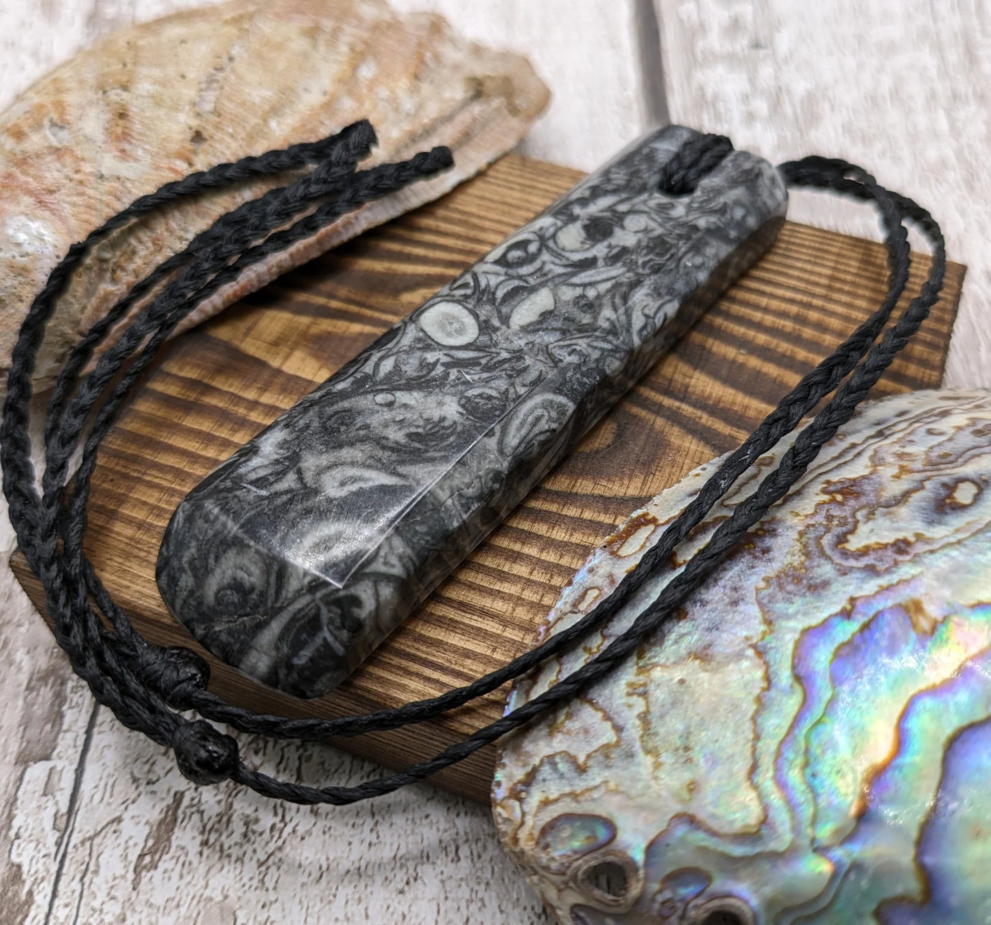 Orthoseras and goniatite fossil bed rock unisex toki pendant.