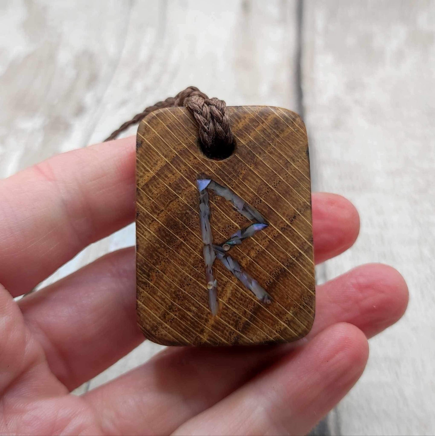 Raidho oak wood rune pendant with mussel shell inlay.