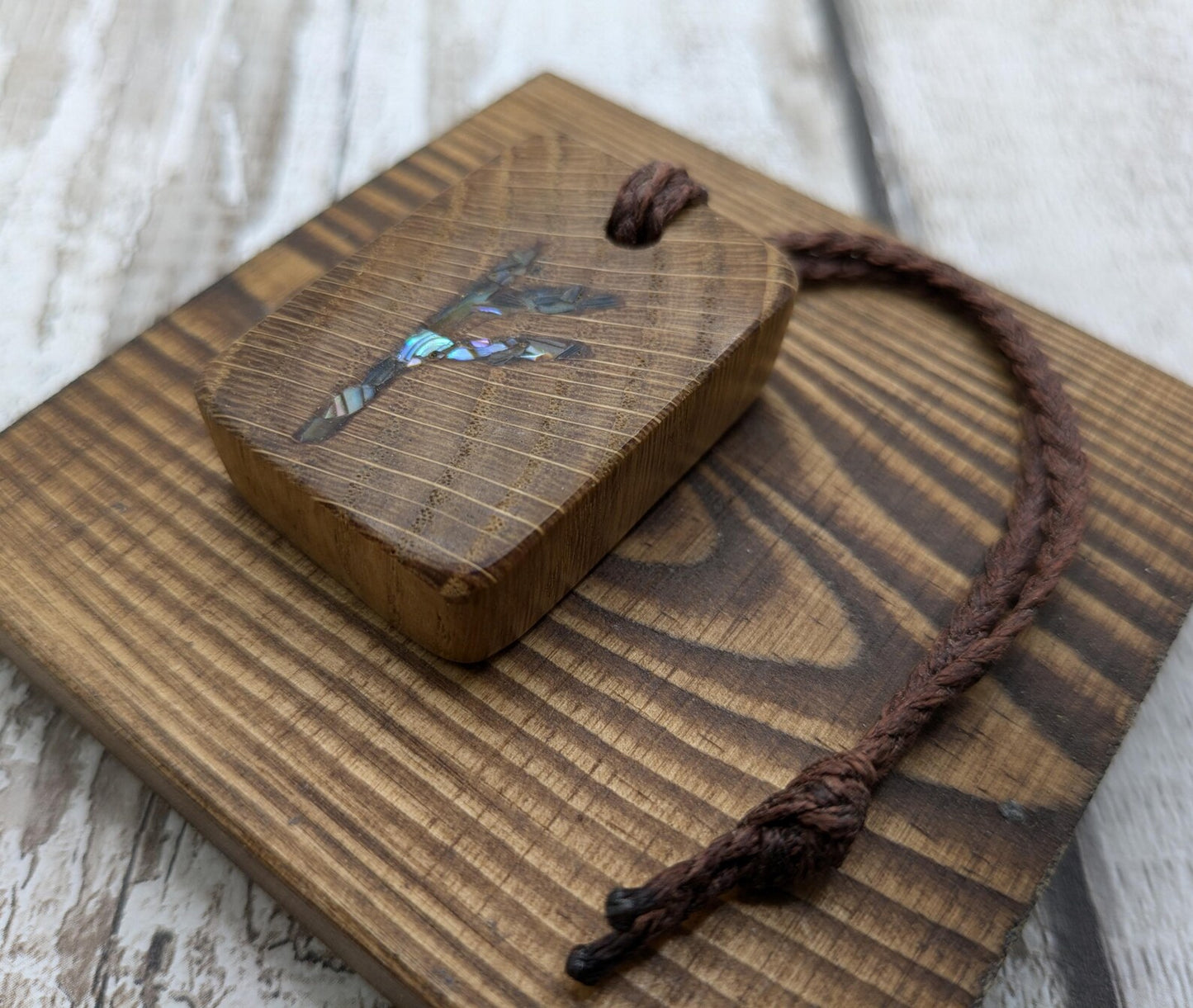 Oak wood Fehu rune Christmas decorations with rainbow Pāua.