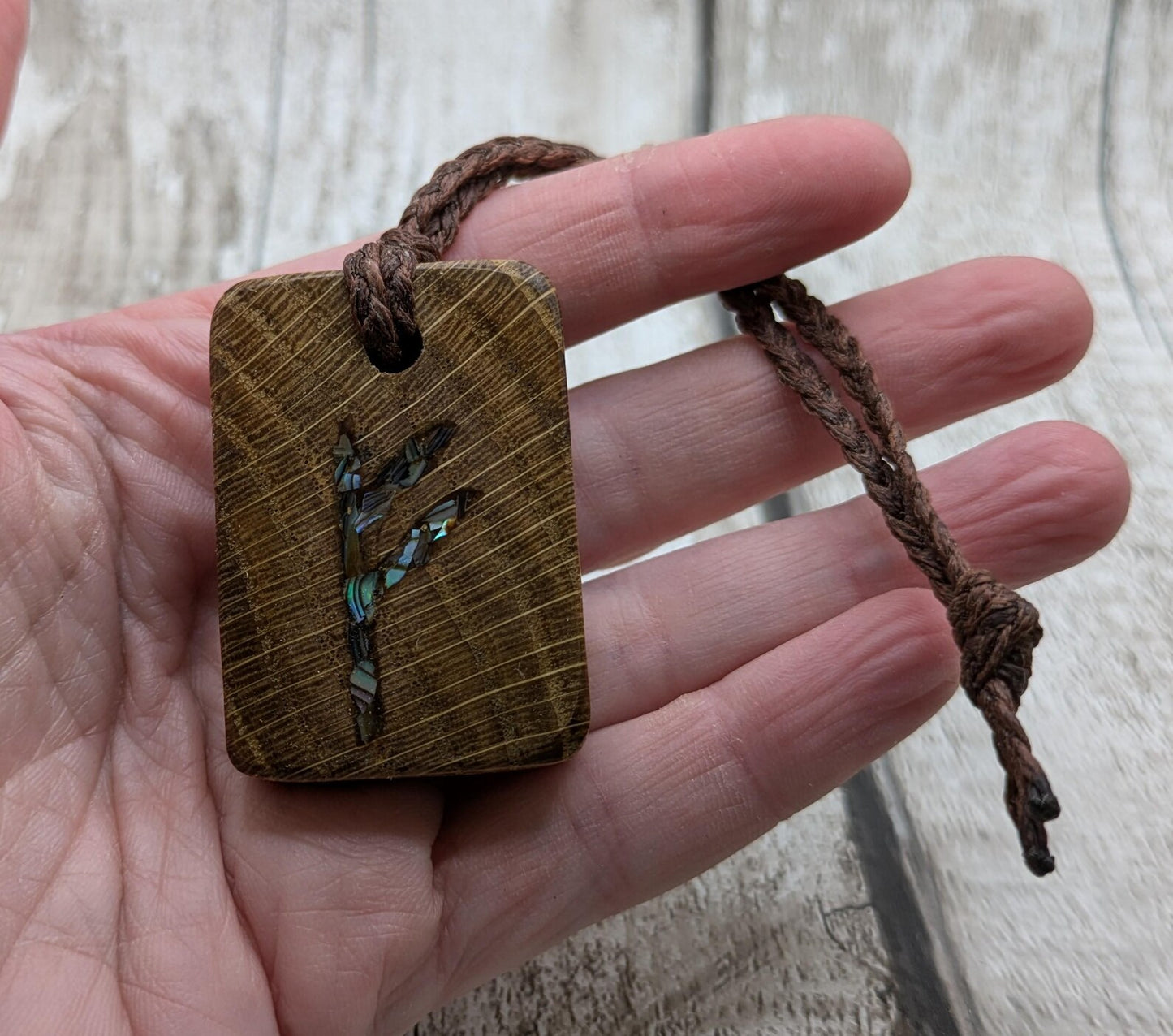 Oak wood Fehu rune Christmas decorations with rainbow Pāua.