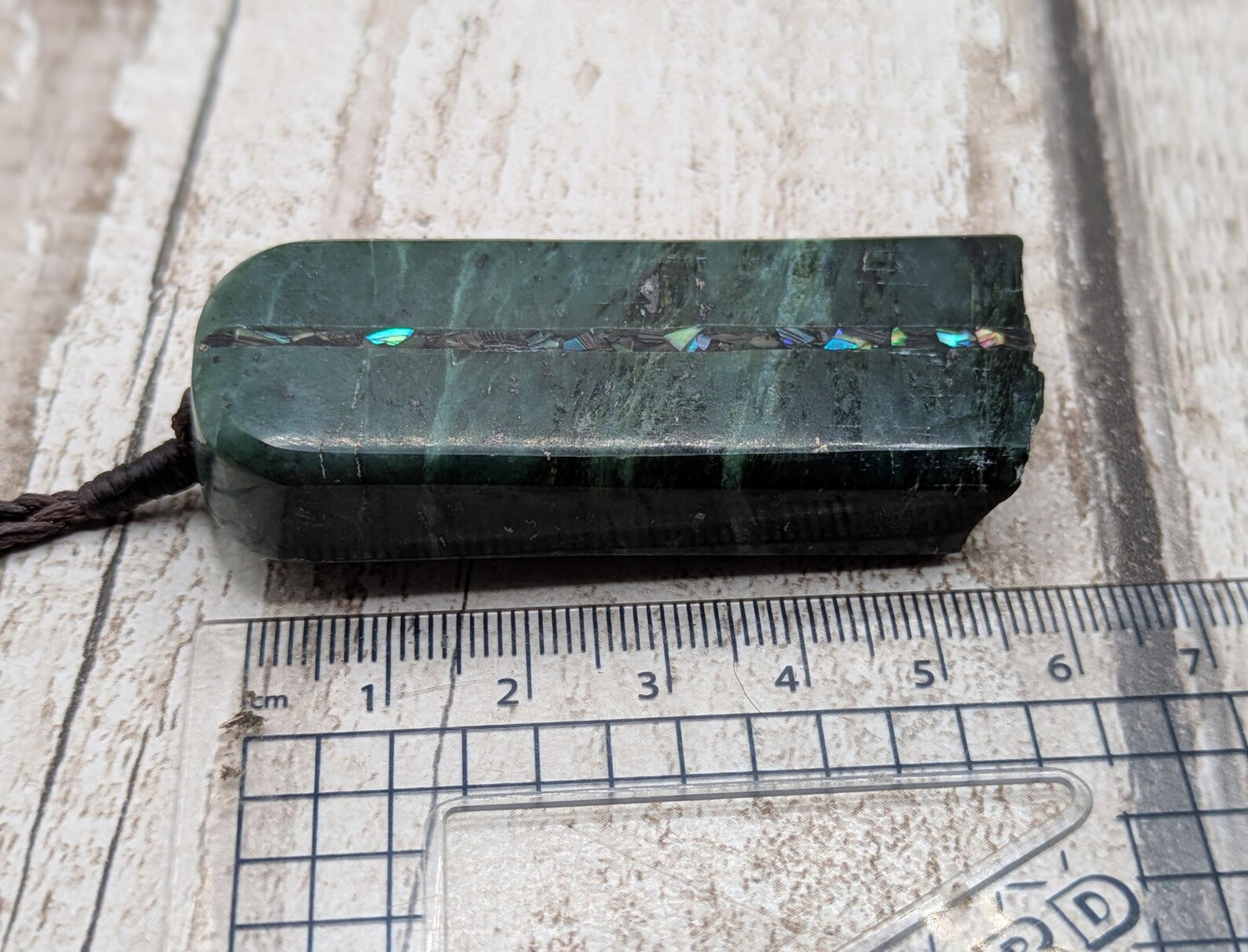 new Zealand pounamu serpentine with rainbownpāua inlay and raw edge.