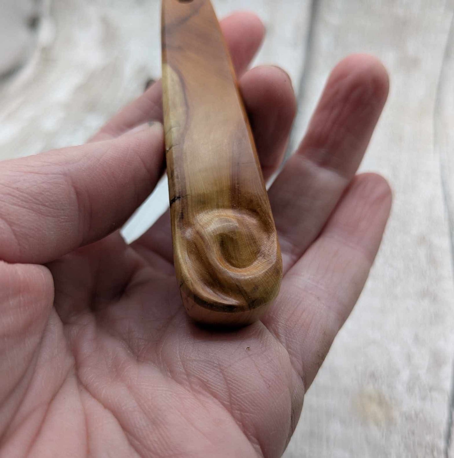 Yew wood roimata teardrop pendant with Koru spiral.