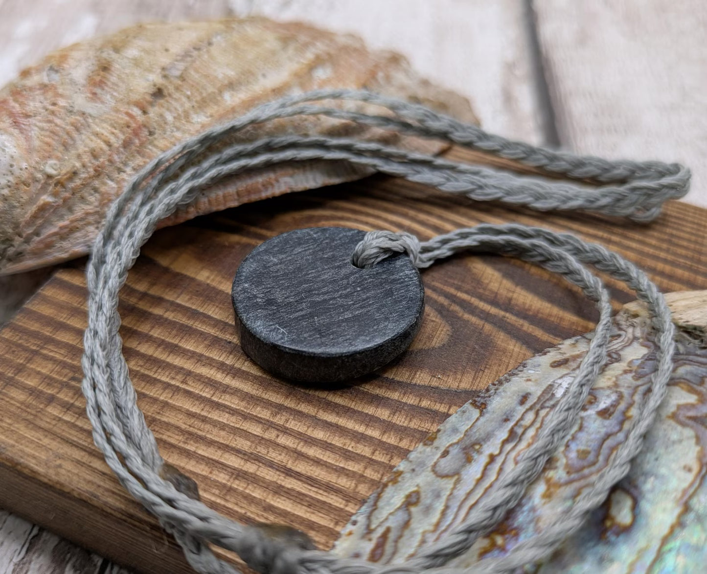 Low grade Shungite asymmetric disc pendants.
