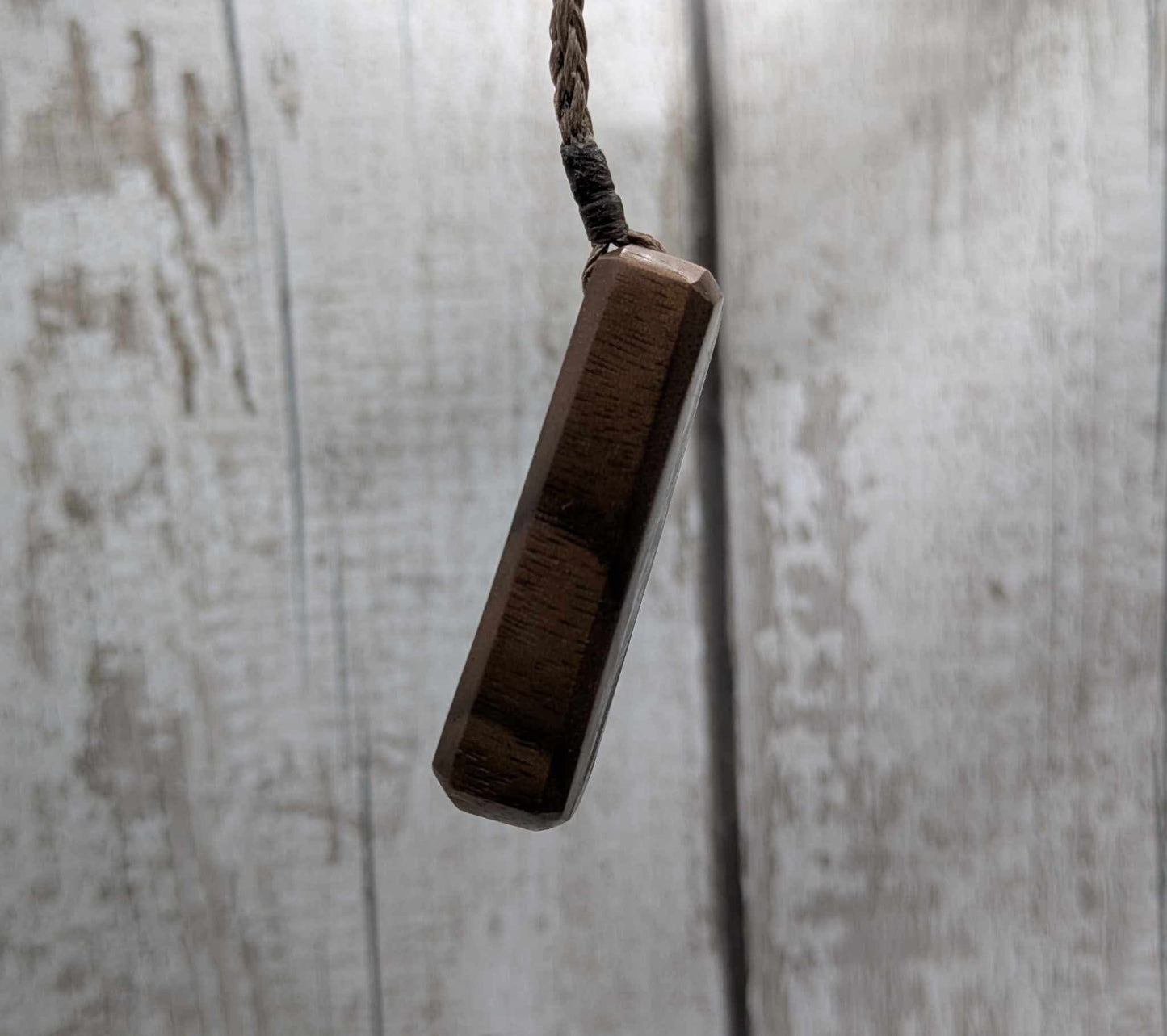 Walnut wood pendant with mussel shell inlay.