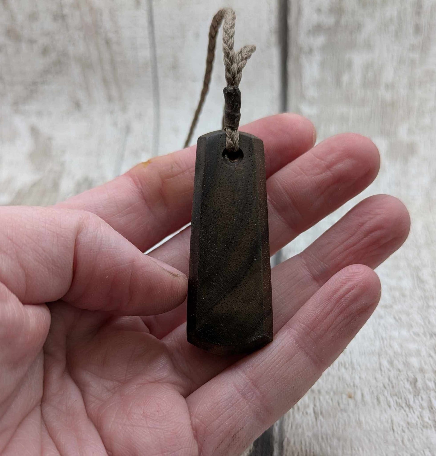 Walnut wood pendant with mussel shell inlay.