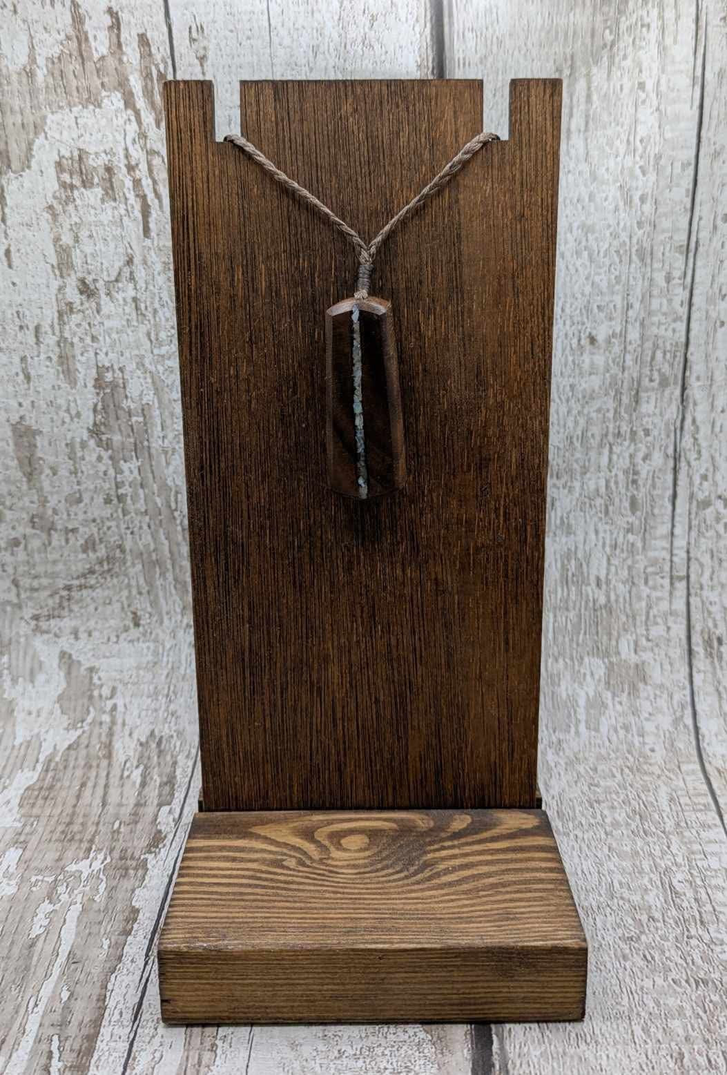 Walnut wood pendant with mussel shell inlay.