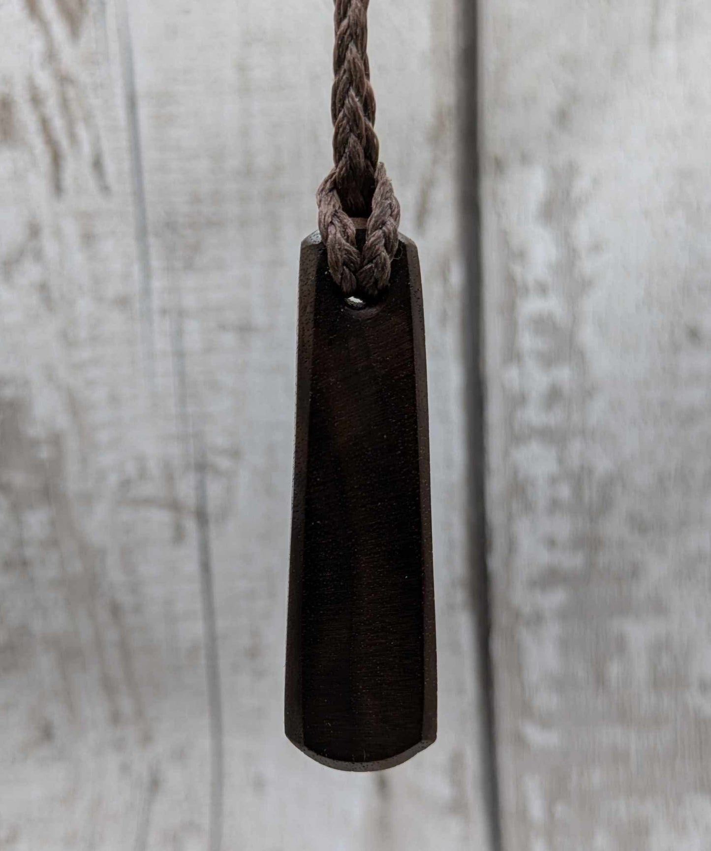 Walnut wood pendant with mussel shell inlay.