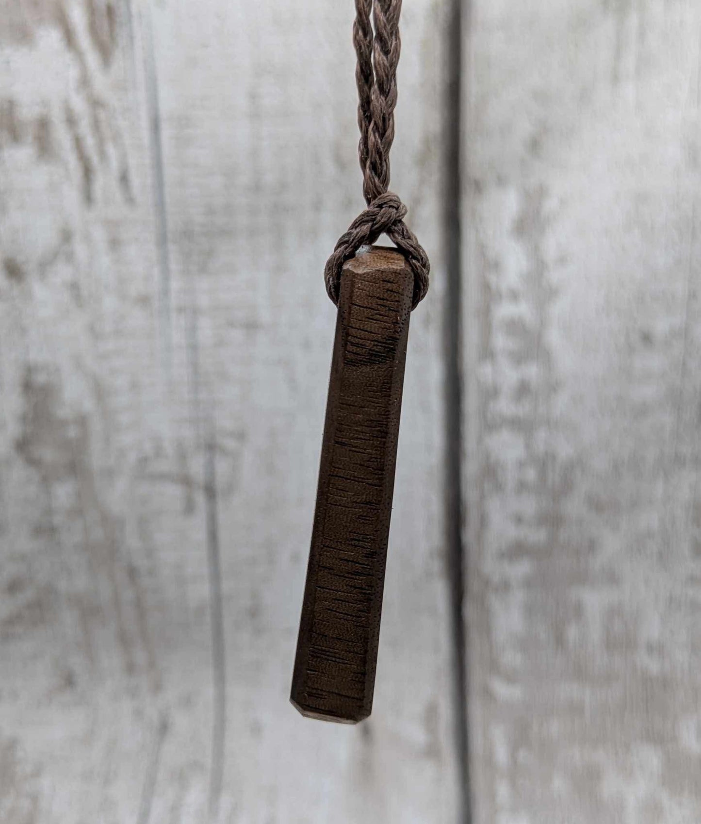 Walnut wood pendant with mussel shell inlay.