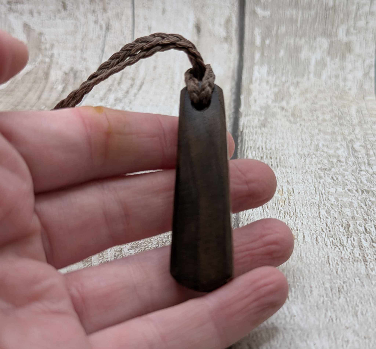 Walnut wood pendant with mussel shell inlay.