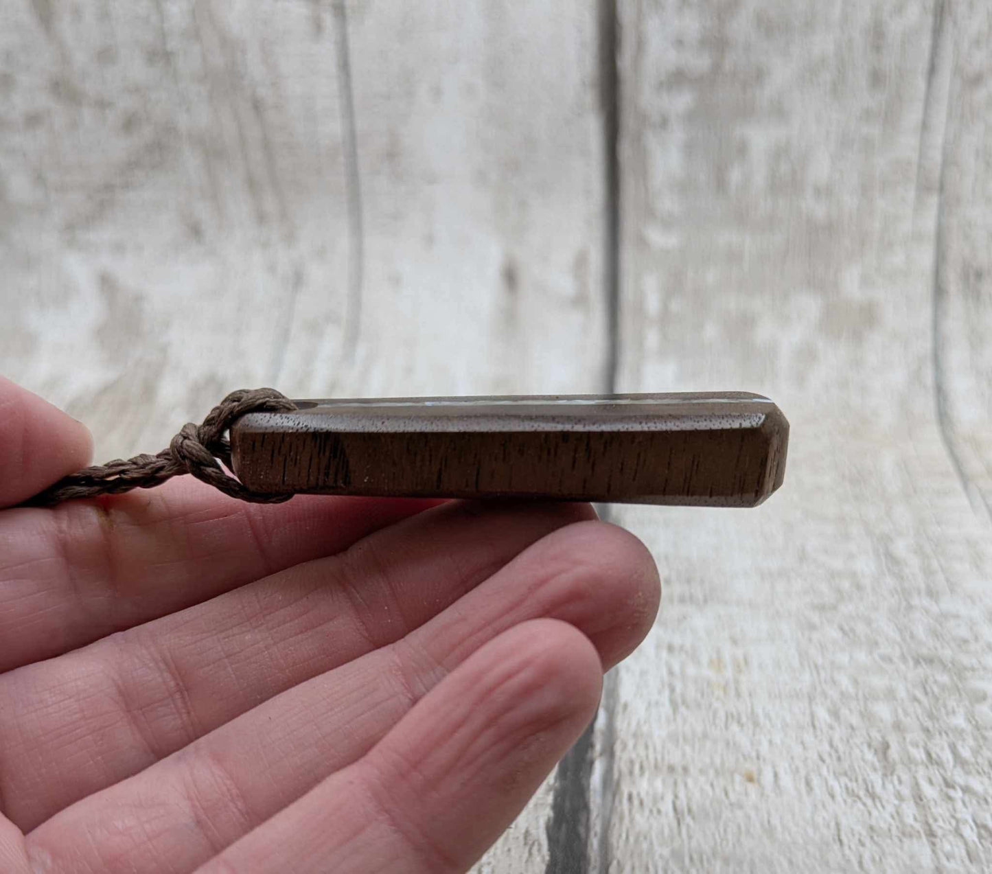 Walnut wood pendant with mussel shell inlay.