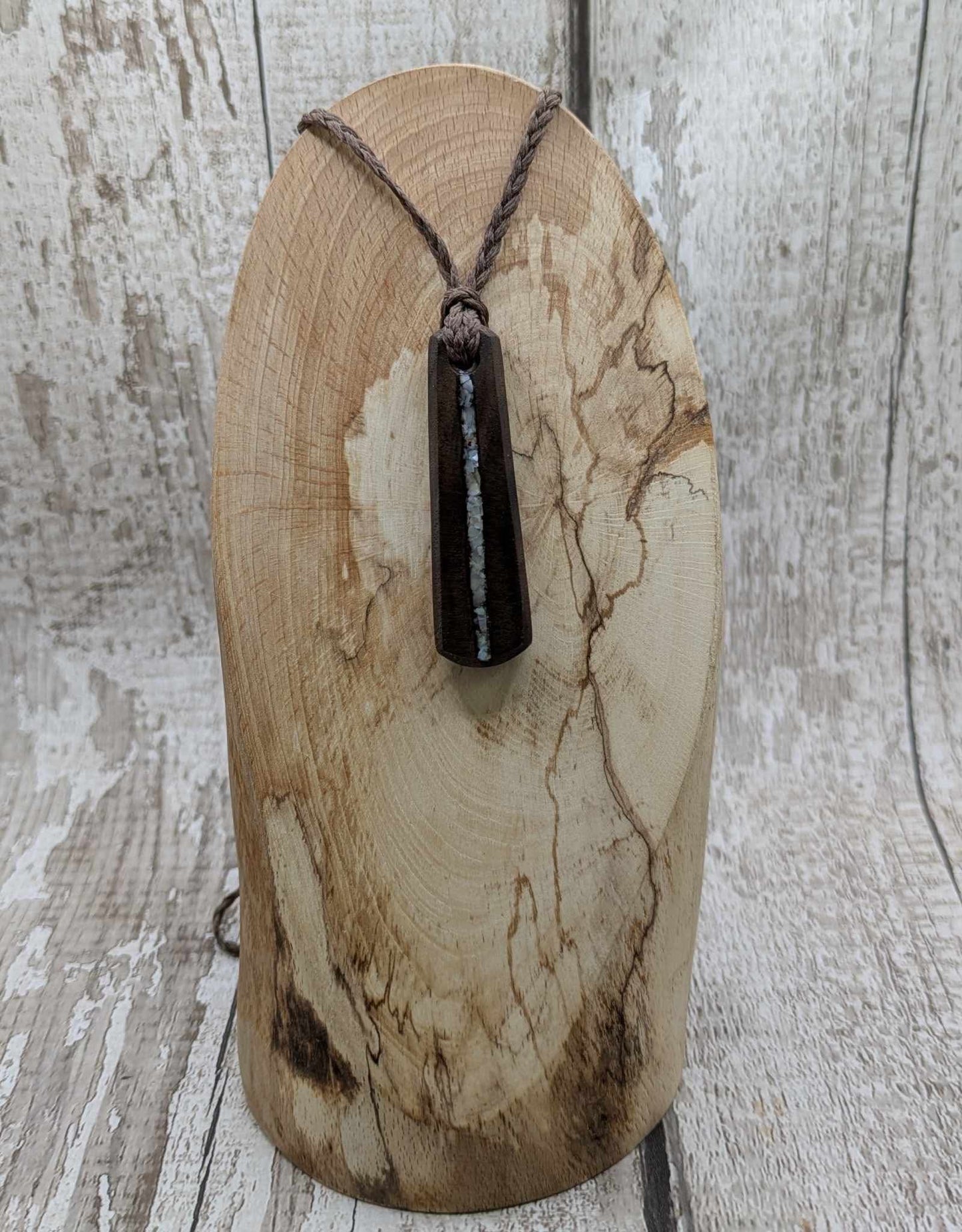 Walnut wood pendant with mussel shell inlay.