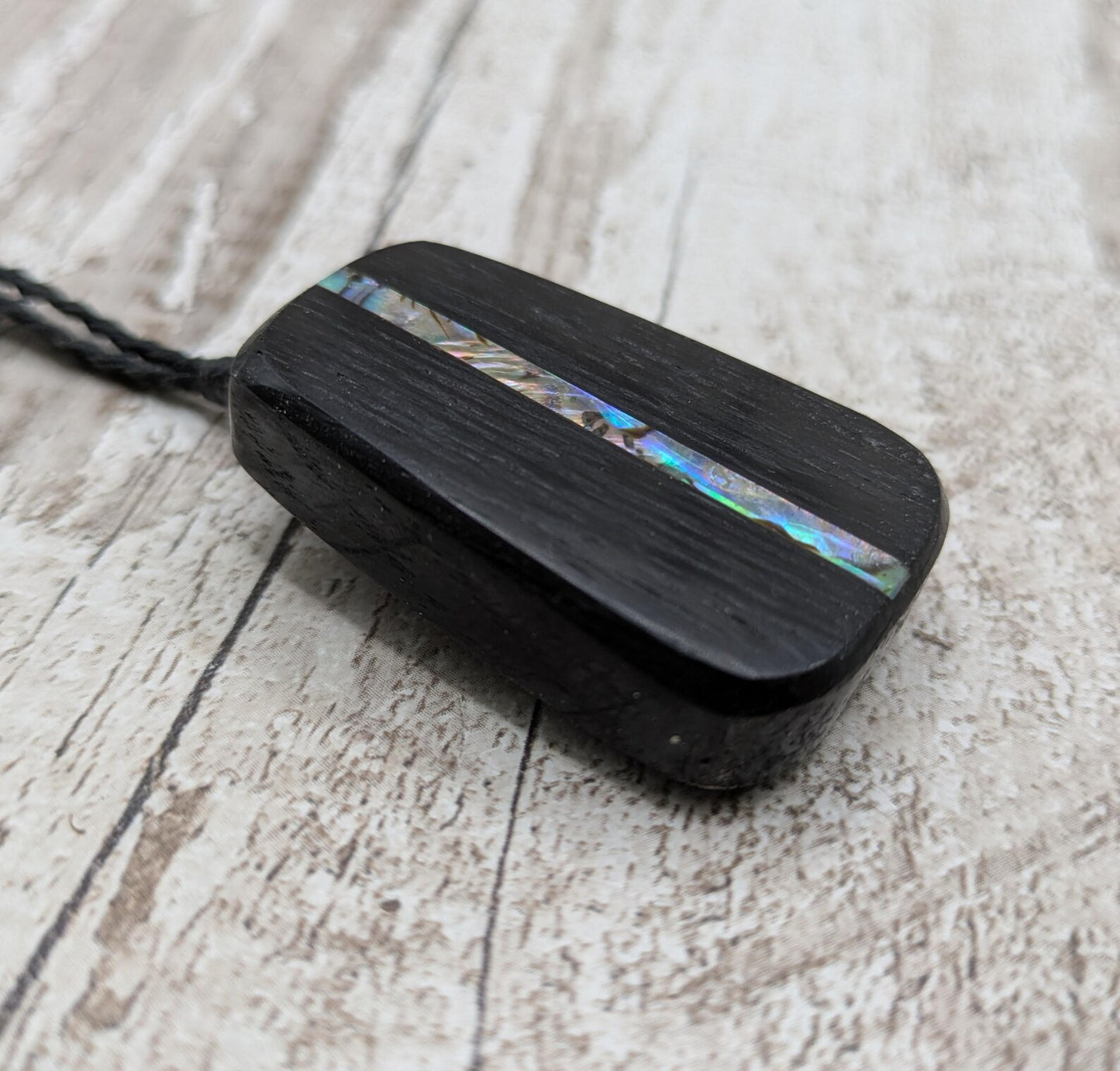 Fenland bog pendant with pāua shell inlay.