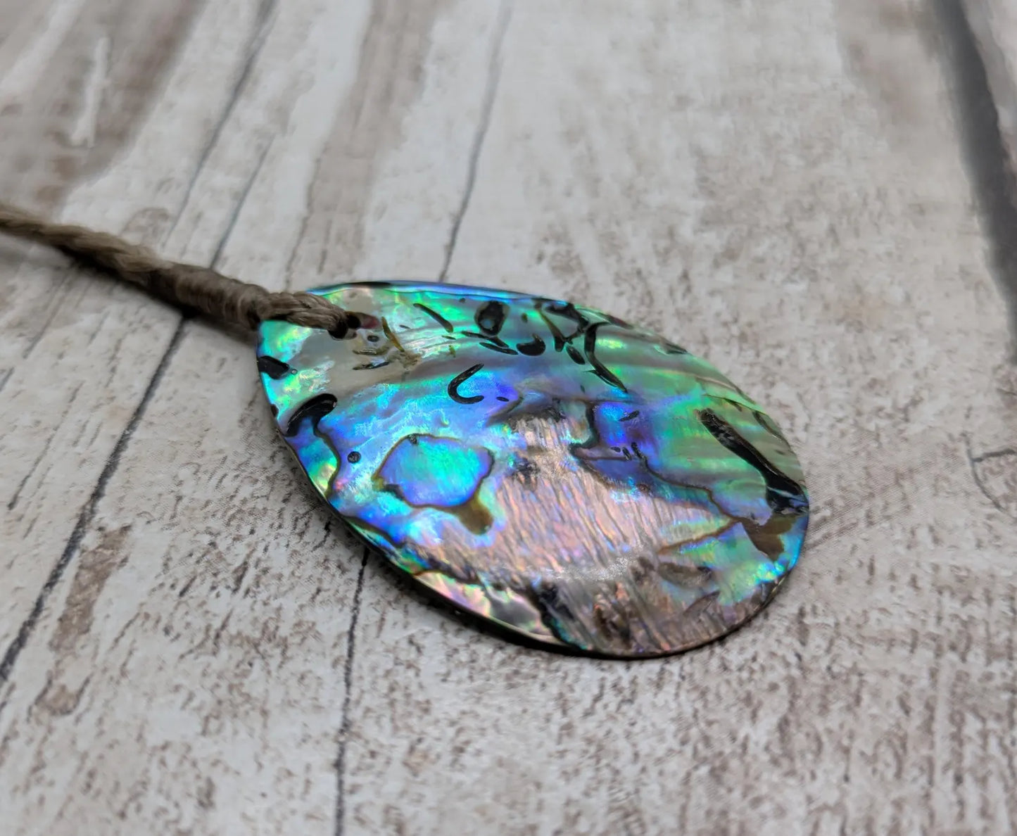 Carved NZ Pāua Shell Oval Pendant – Handcrafted Rainbow Abalone Jewel, Ocean-Inspired fashion, iridescent amulet.