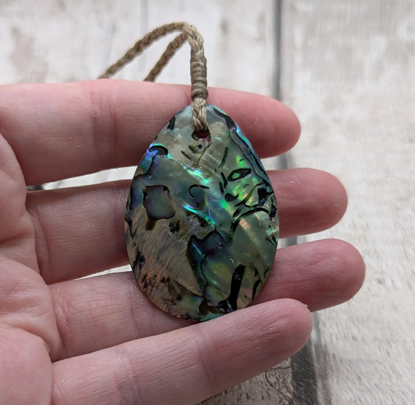Carved NZ Pāua Shell Oval Pendant – Handcrafted Rainbow Abalone Jewel, Ocean-Inspired fashion, iridescent amulet.