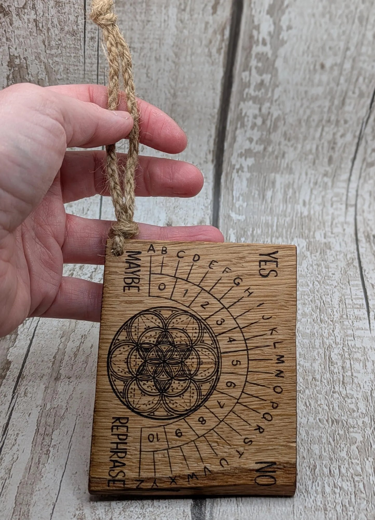 Oak wood travel sized pendulum board with geometric design.