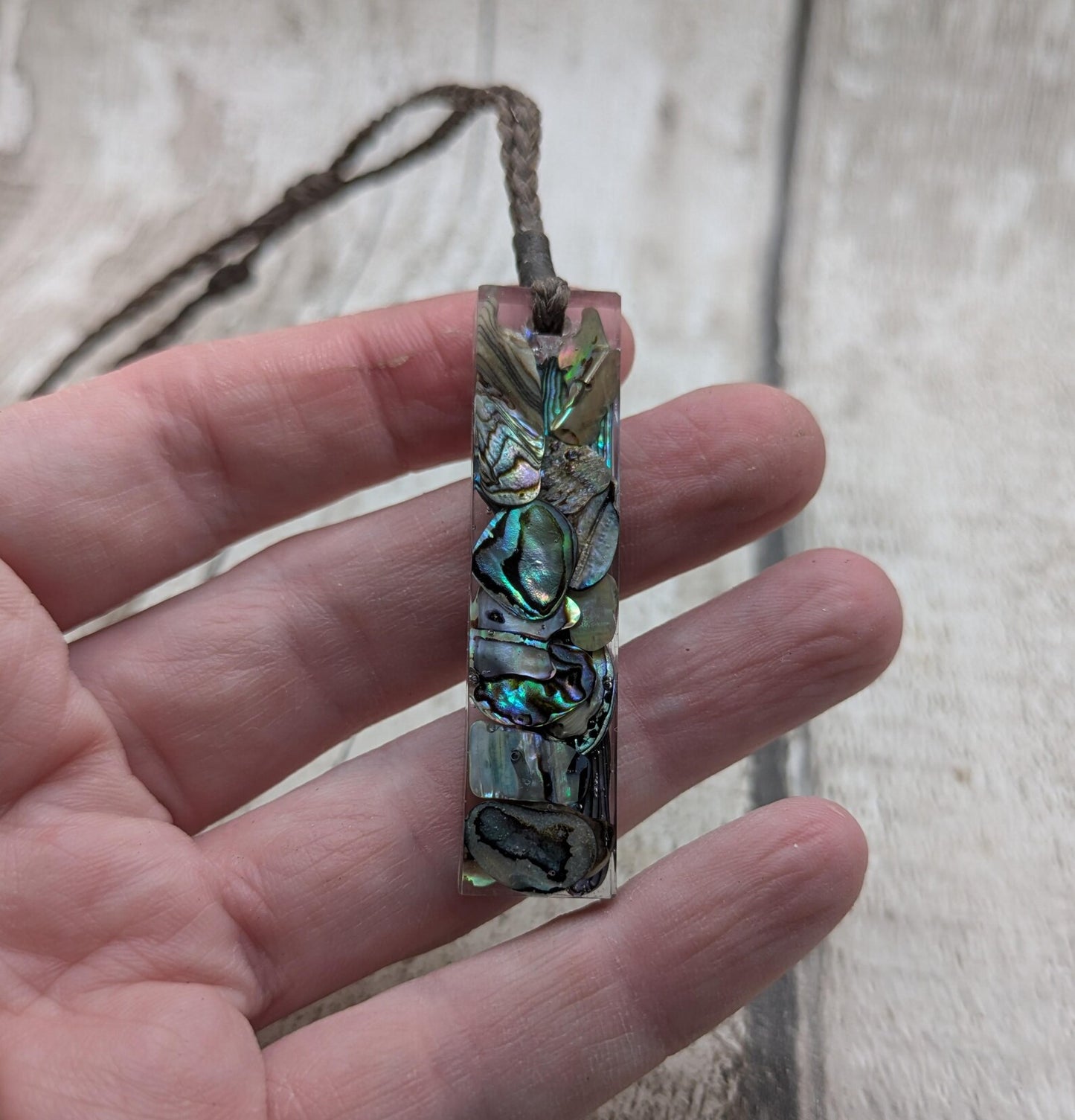 One New Zealand rainbow pāua chips in resin.