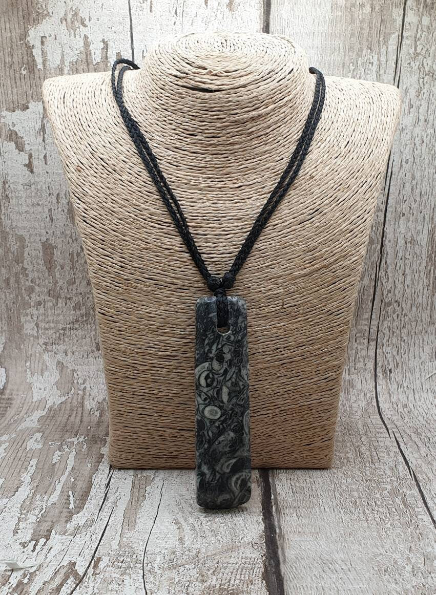 Orthoseras and goniatite fossil bed rock unisex toki pendant.