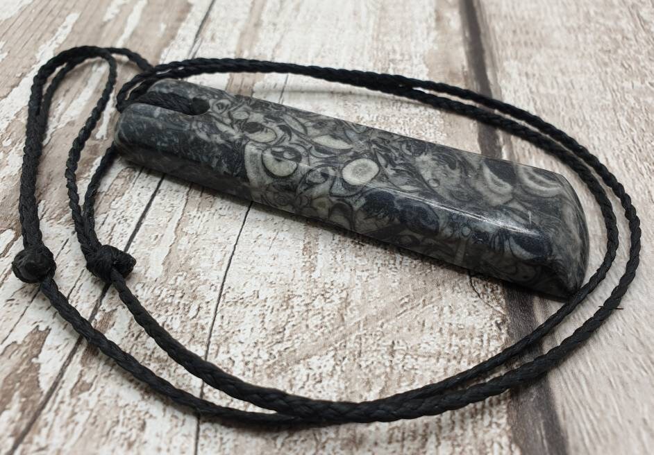 Orthoseras and goniatite fossil bed rock unisex toki pendant.