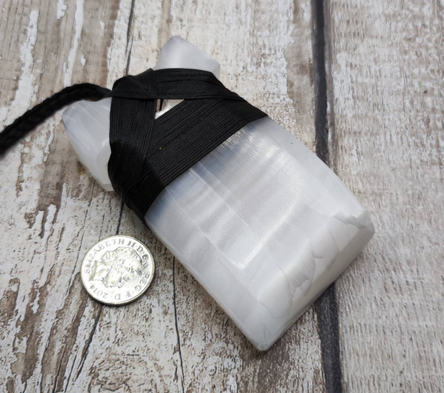 Large selenite hei toki adze carved pendant.