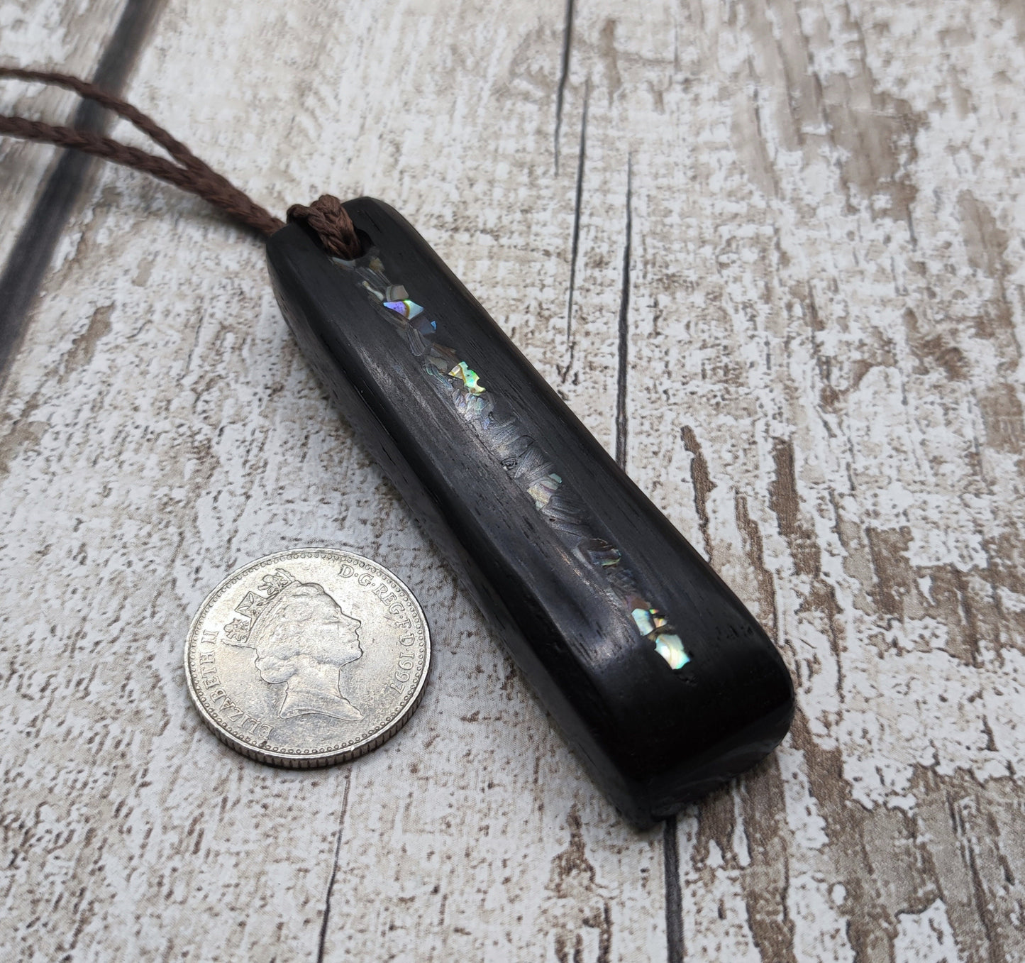Bog oak and NZ rainbow pāua shell toki pendant.