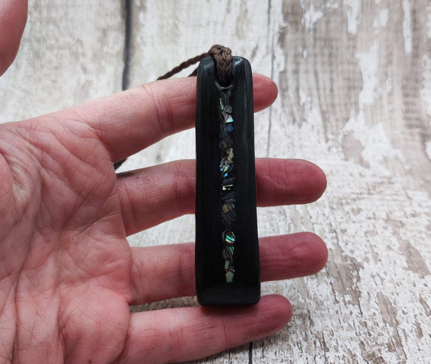 Bog oak and NZ rainbow pāua shell toki pendant.