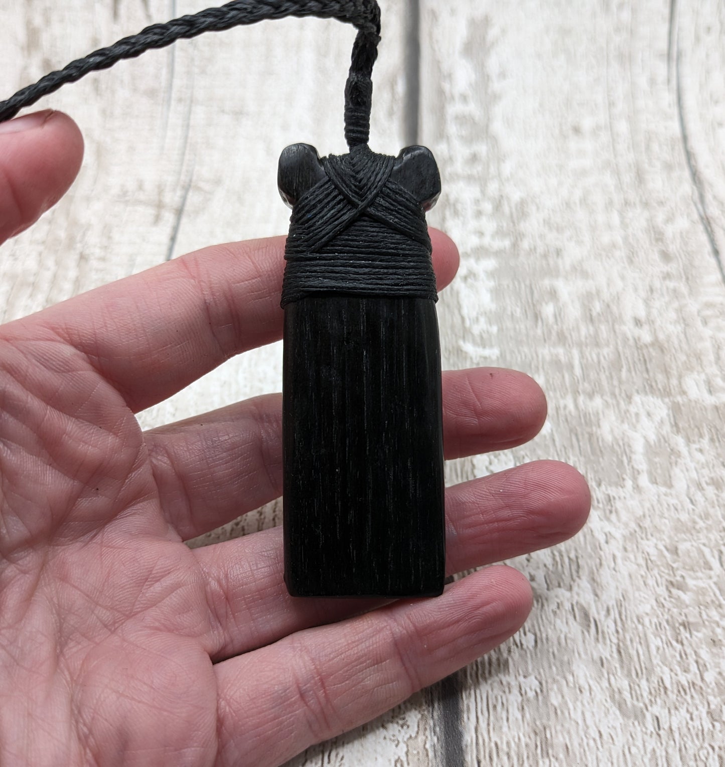 Fenland bog oak hei toki adze with NZ pāua shell pendant.