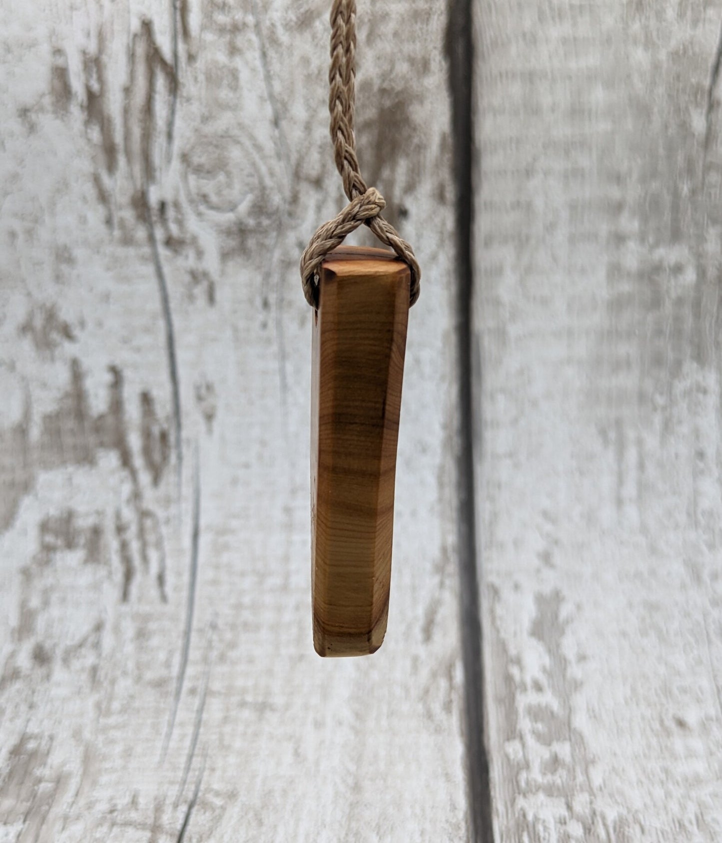 Faceted yew wood slice pendant.