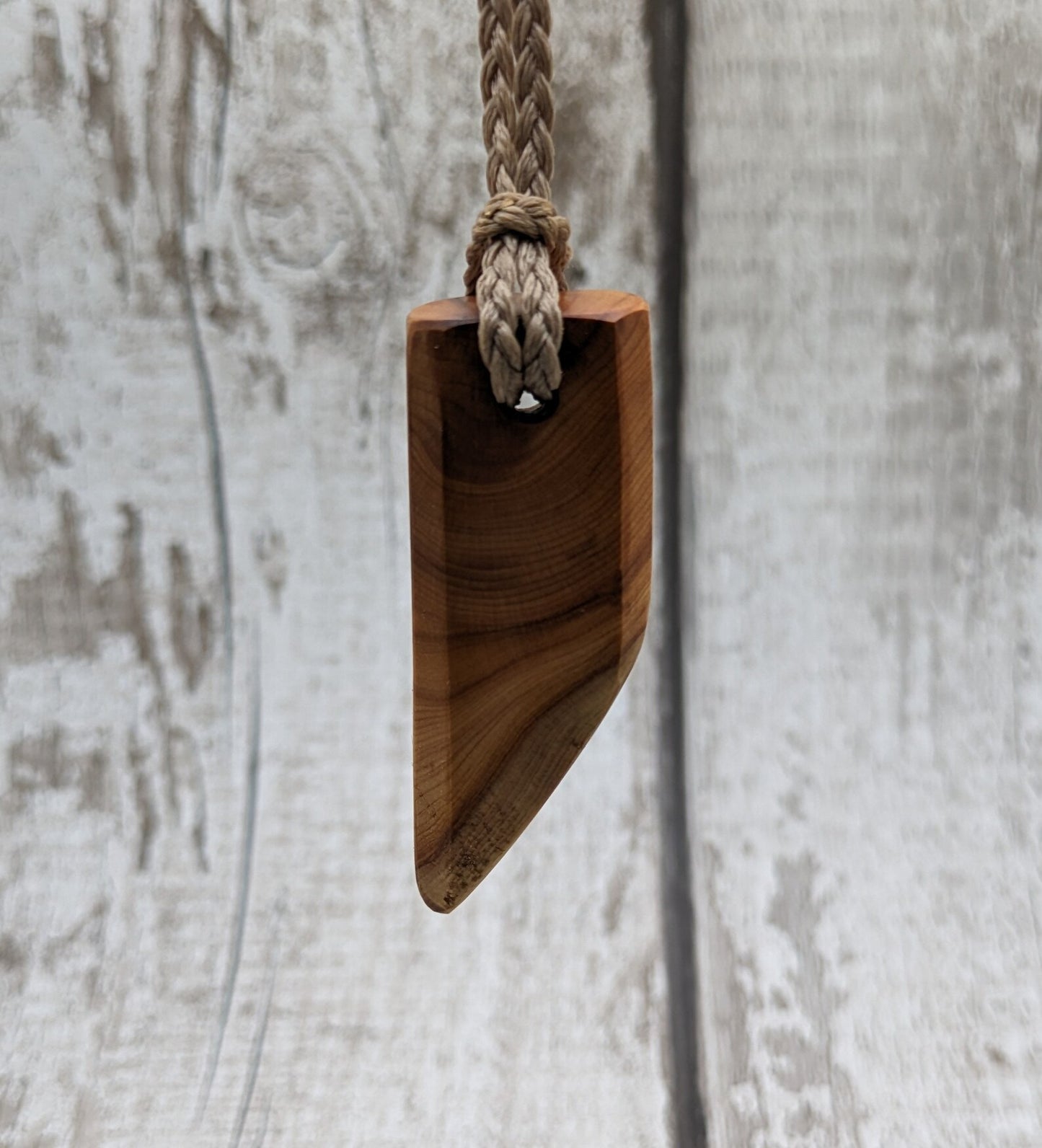 Faceted yew wood slice pendant.