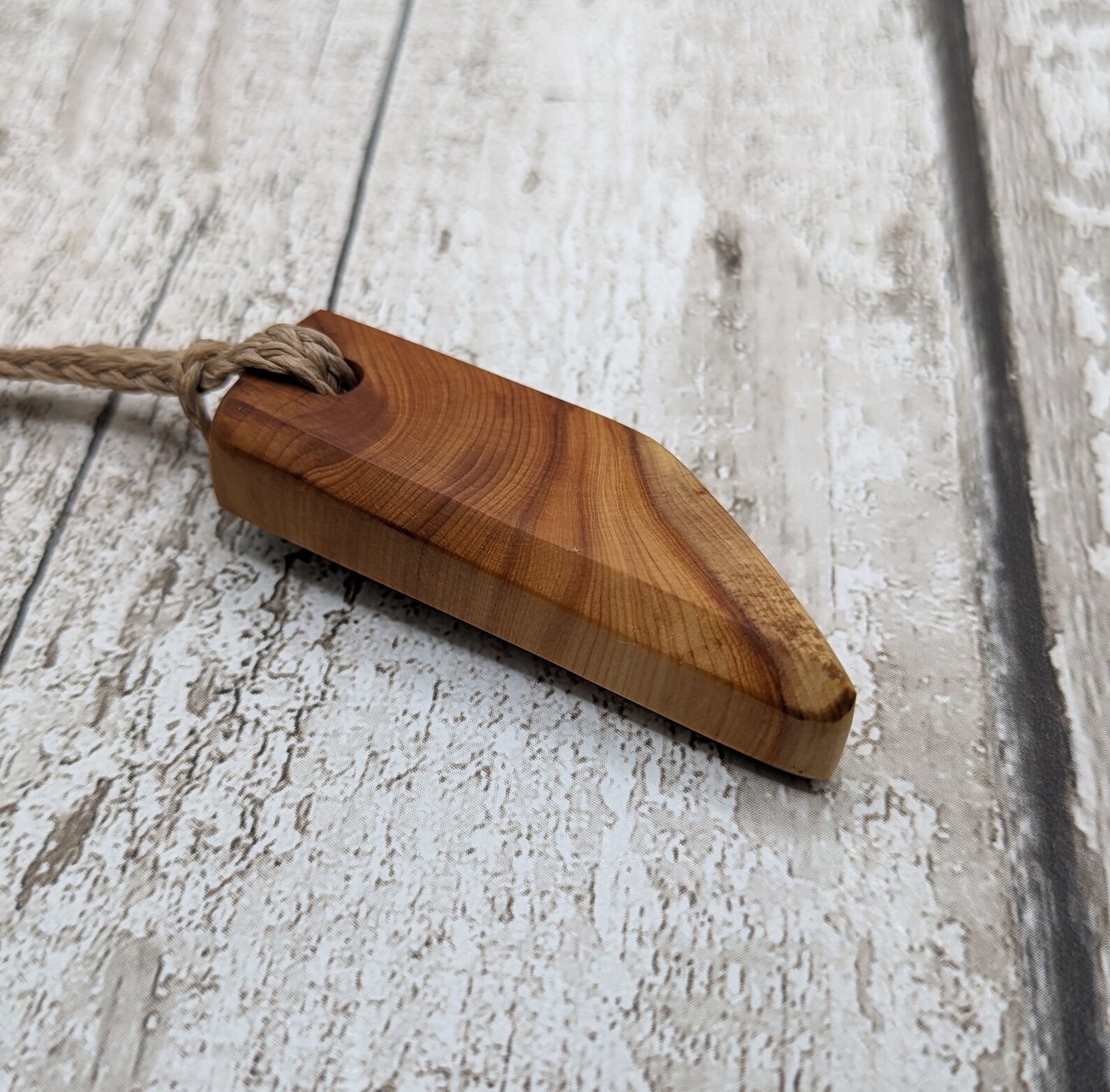 Faceted yew wood slice pendant.