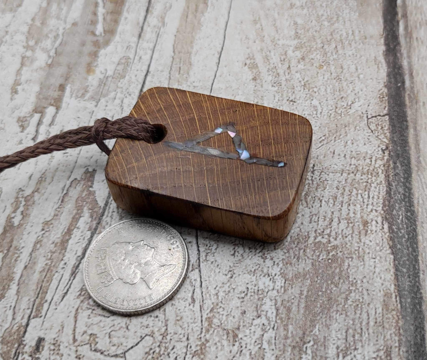 Wunjo oak wood rune pendant with mussel shell inlay.