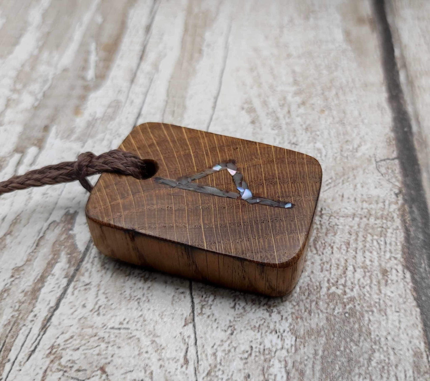Wunjo oak wood rune pendant with mussel shell inlay.