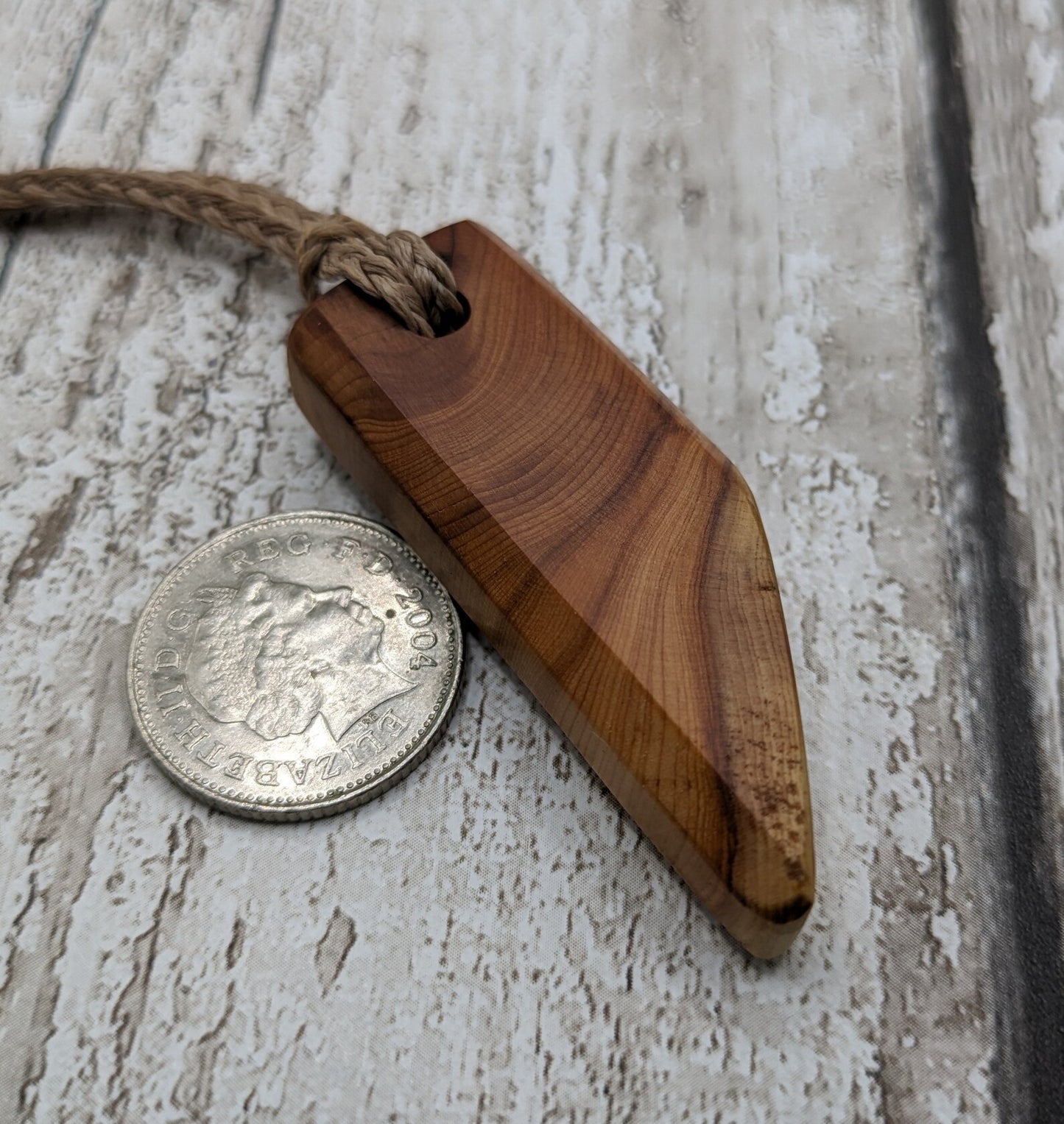 Faceted yew wood slice pendant.