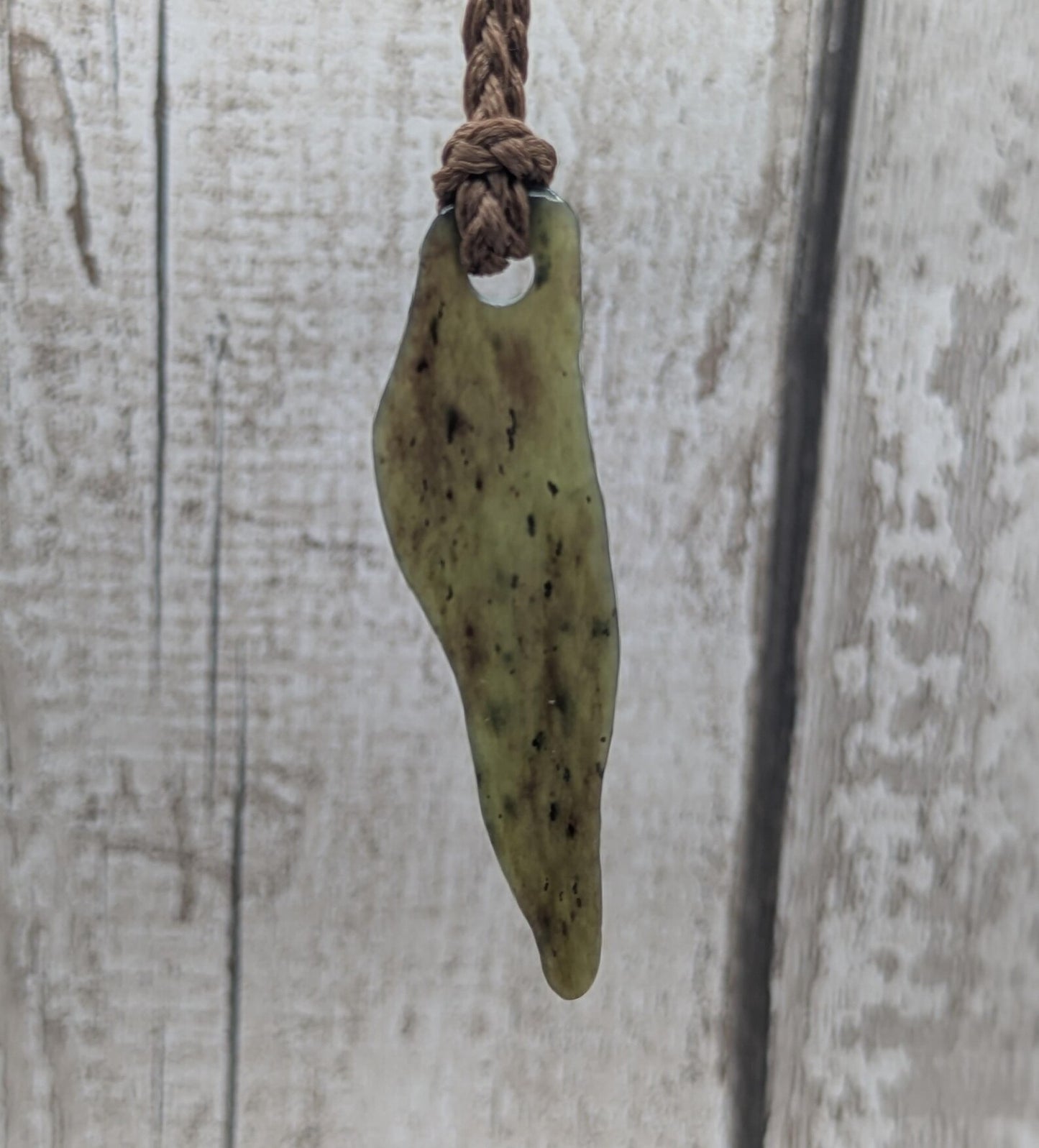 Tumbled New Zealand Pounamu greenstone pendant.