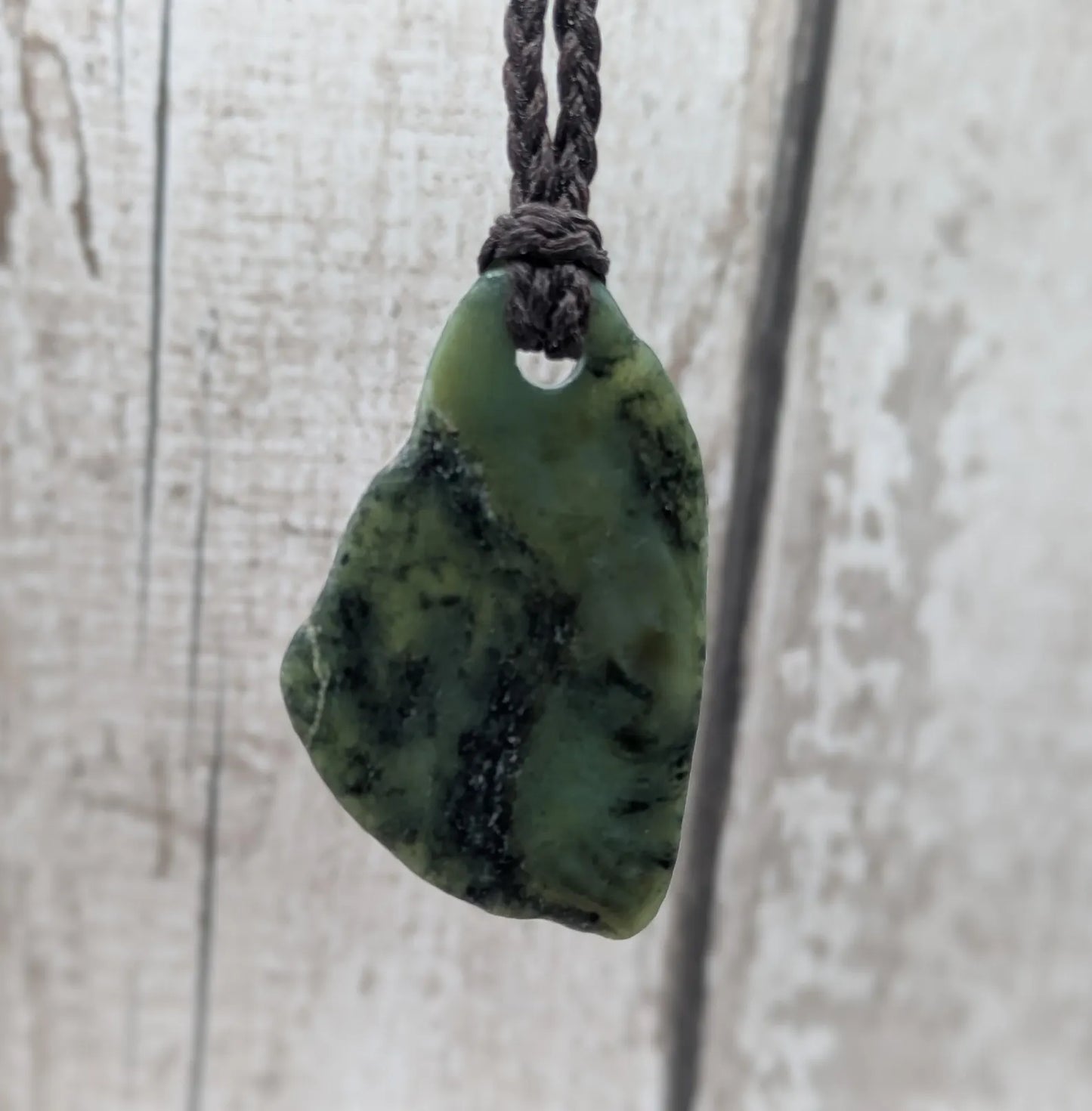 Tumbled New Zealand nephrite jade Pounamu pendant.