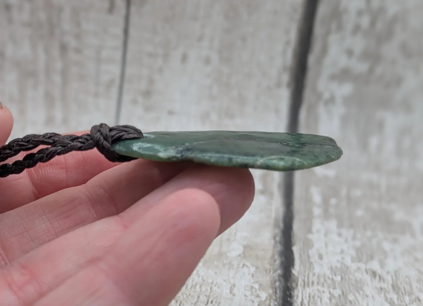 Tumbled New Zealand nephrite jade Pounamu pendant.