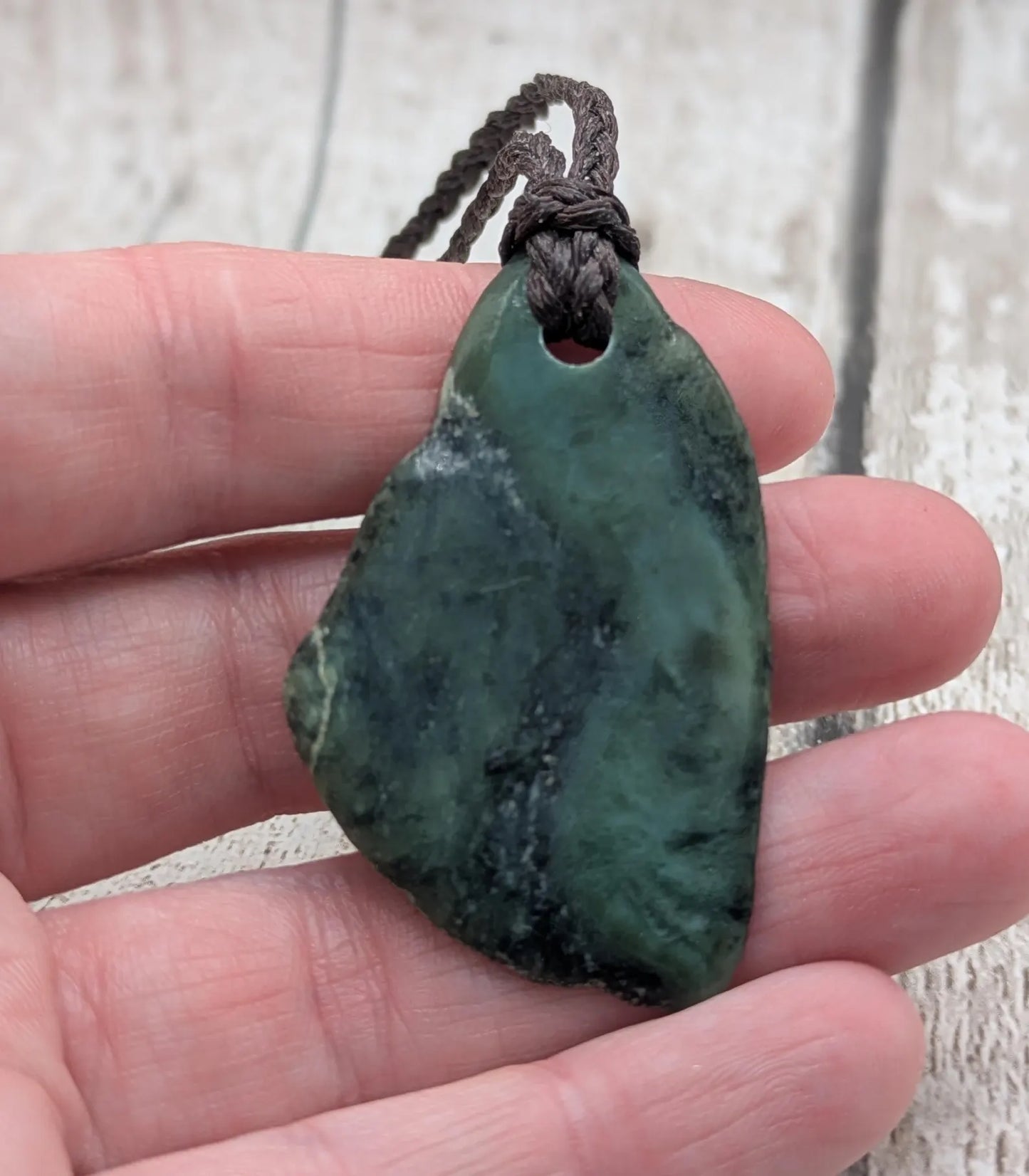 Tumbled New Zealand nephrite jade Pounamu pendant.