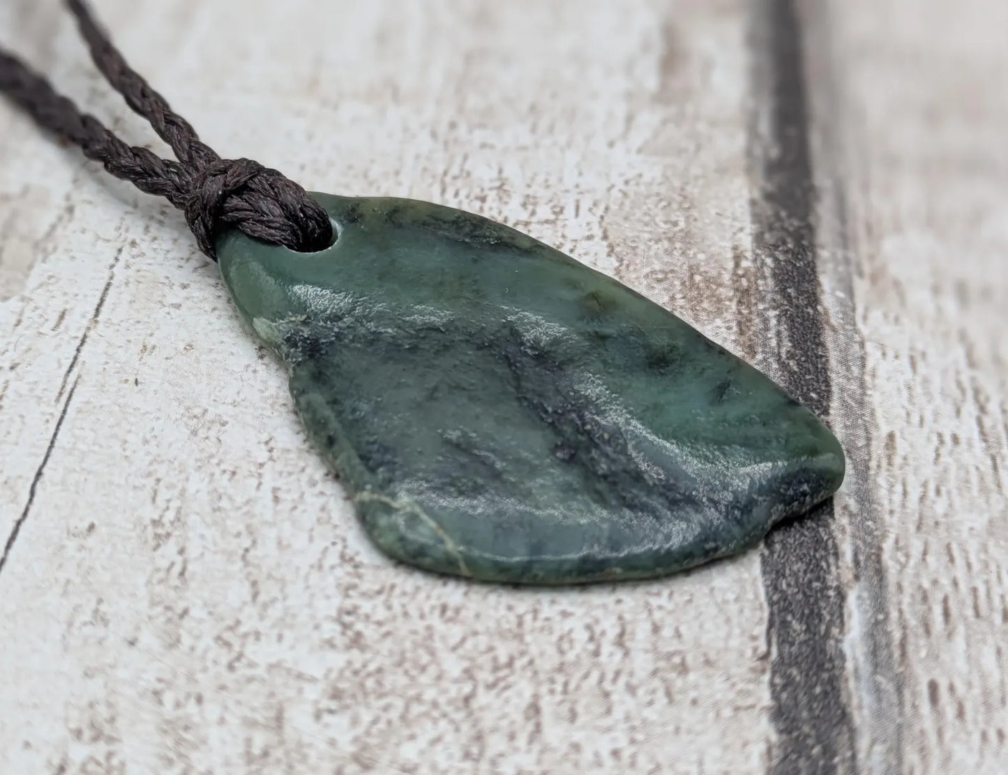 Tumbled New Zealand nephrite jade Pounamu pendant.