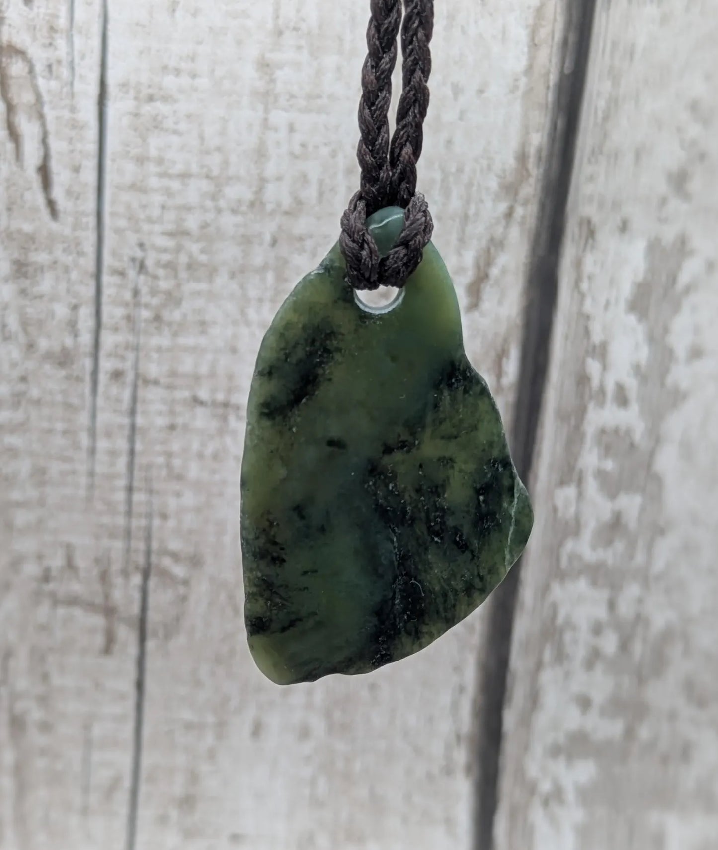 Tumbled New Zealand nephrite jade Pounamu pendant.