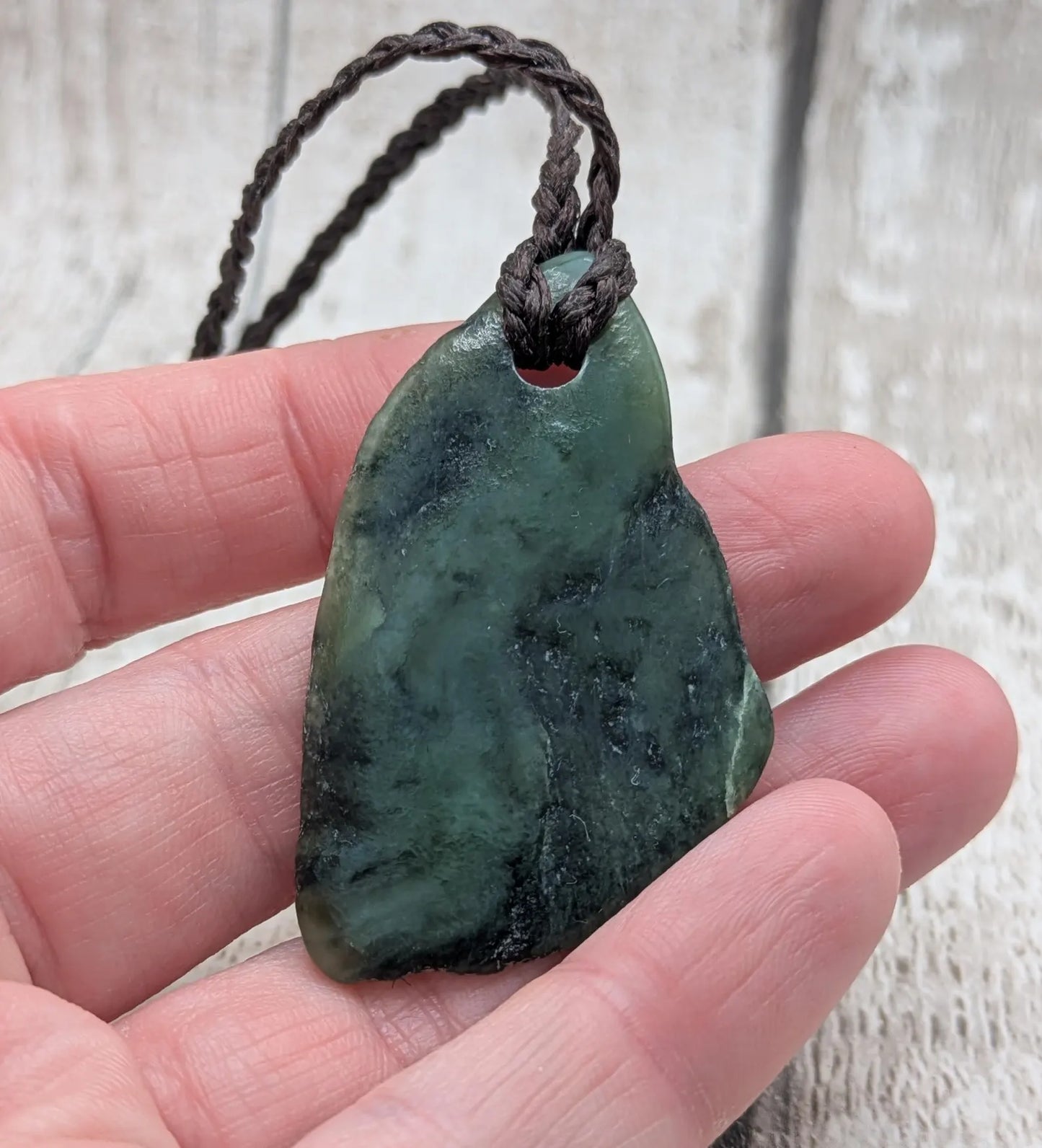 Tumbled New Zealand nephrite jade Pounamu pendant.