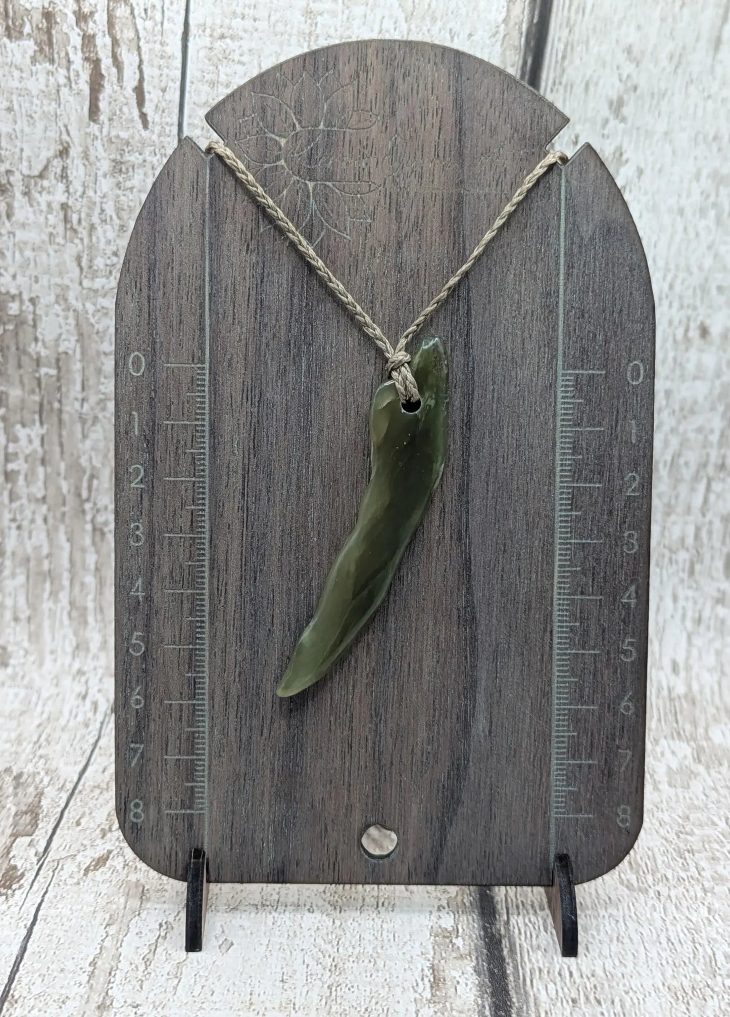 Tumbled nephrite jade Pounamu stone pendant.