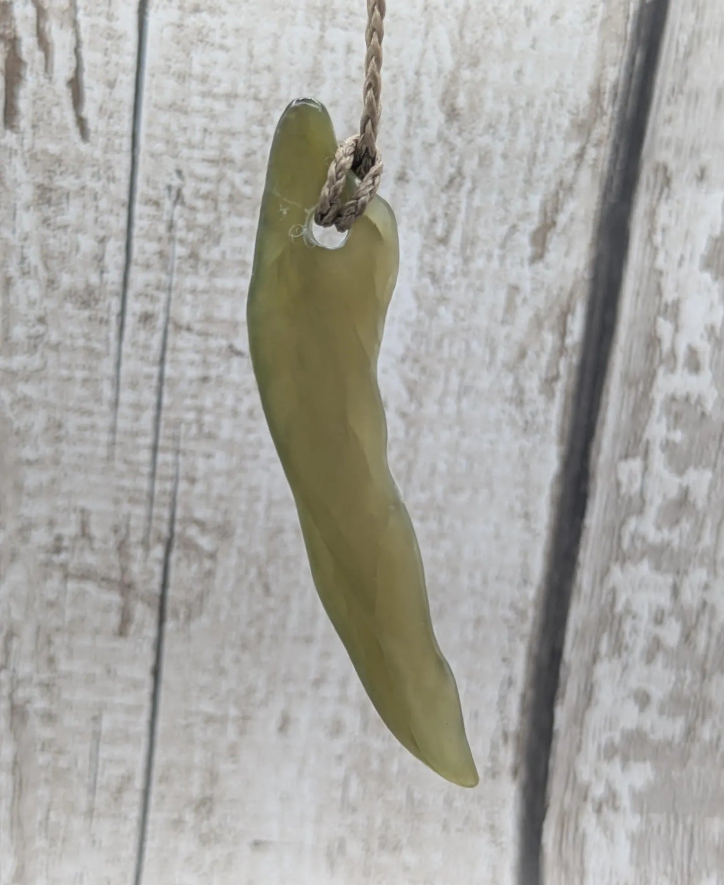 Tumbled nephrite jade Pounamu stone pendant.