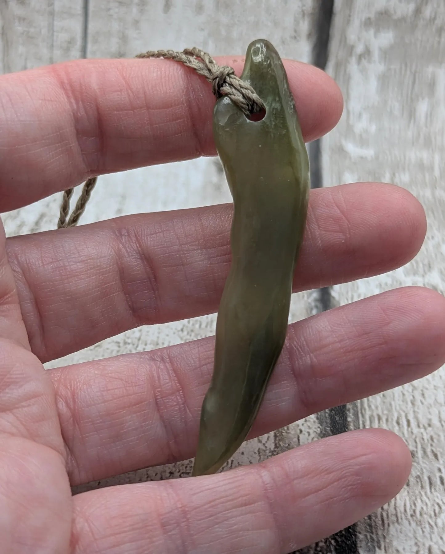 Tumbled nephrite jade Pounamu stone pendant.