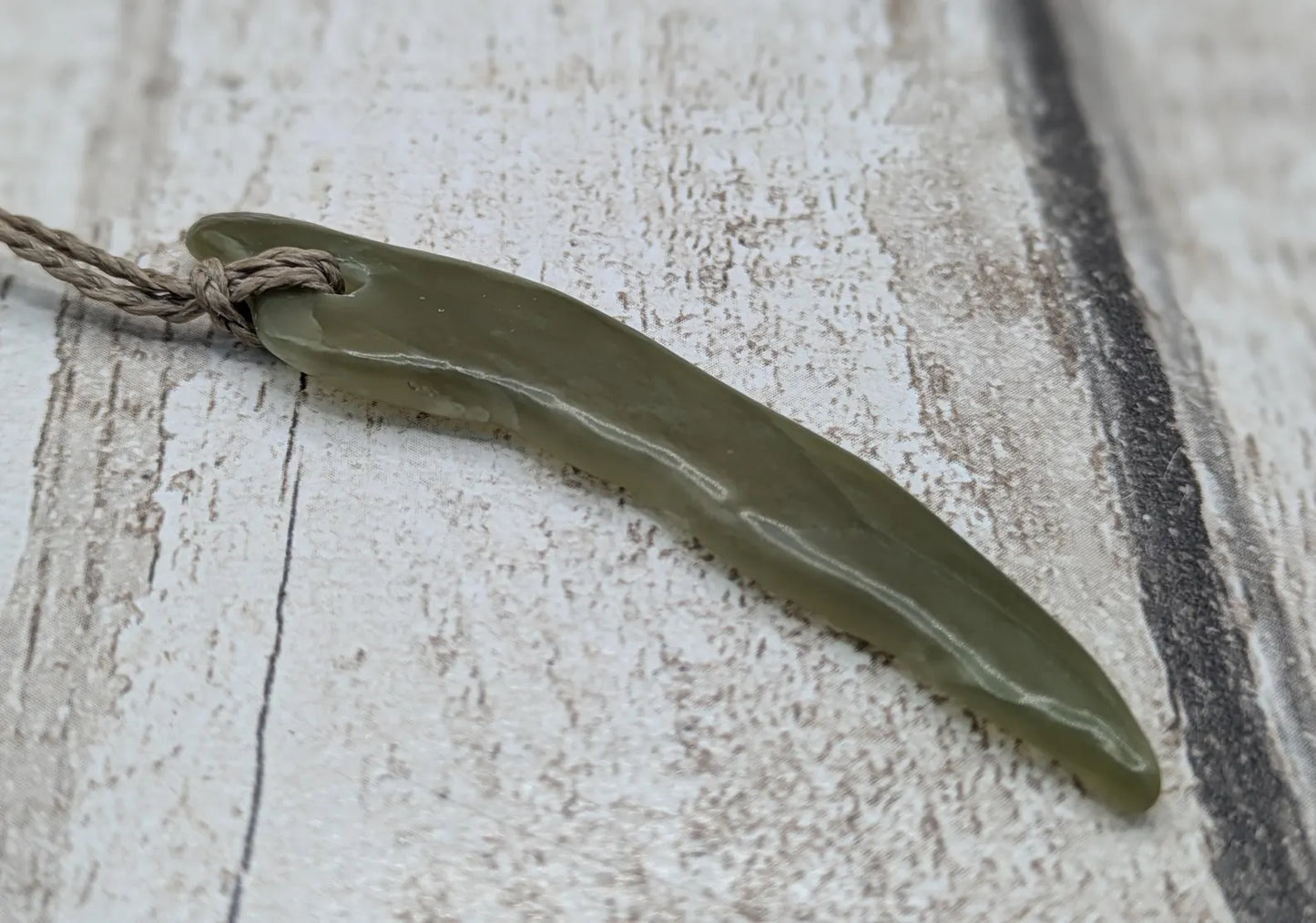 Tumbled nephrite jade Pounamu stone pendant.