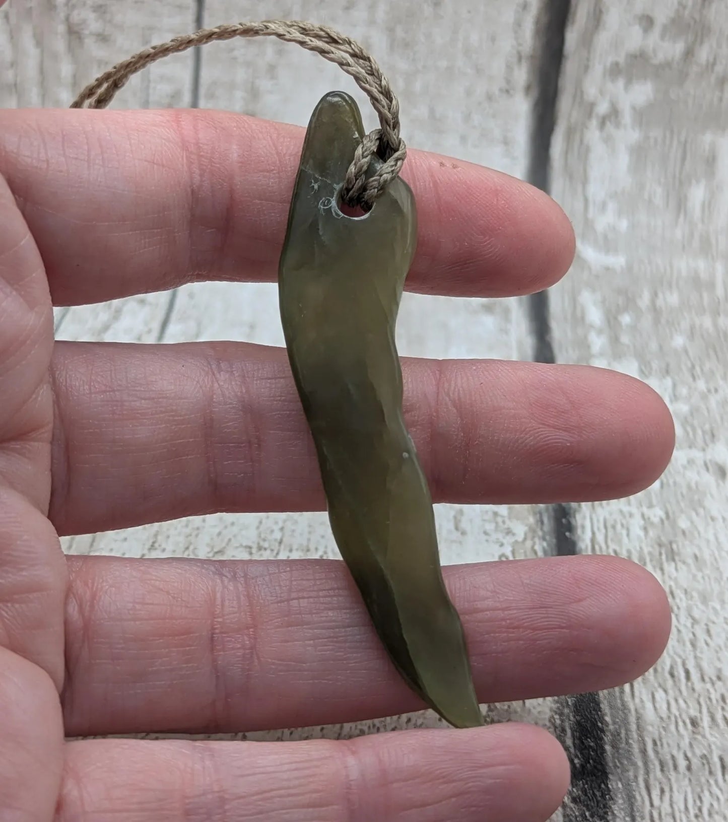 Tumbled nephrite jade Pounamu stone pendant.