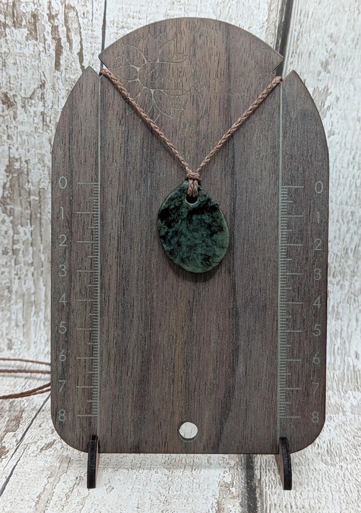 Tumble polished New Zealand Pounamu greenstone pendant.