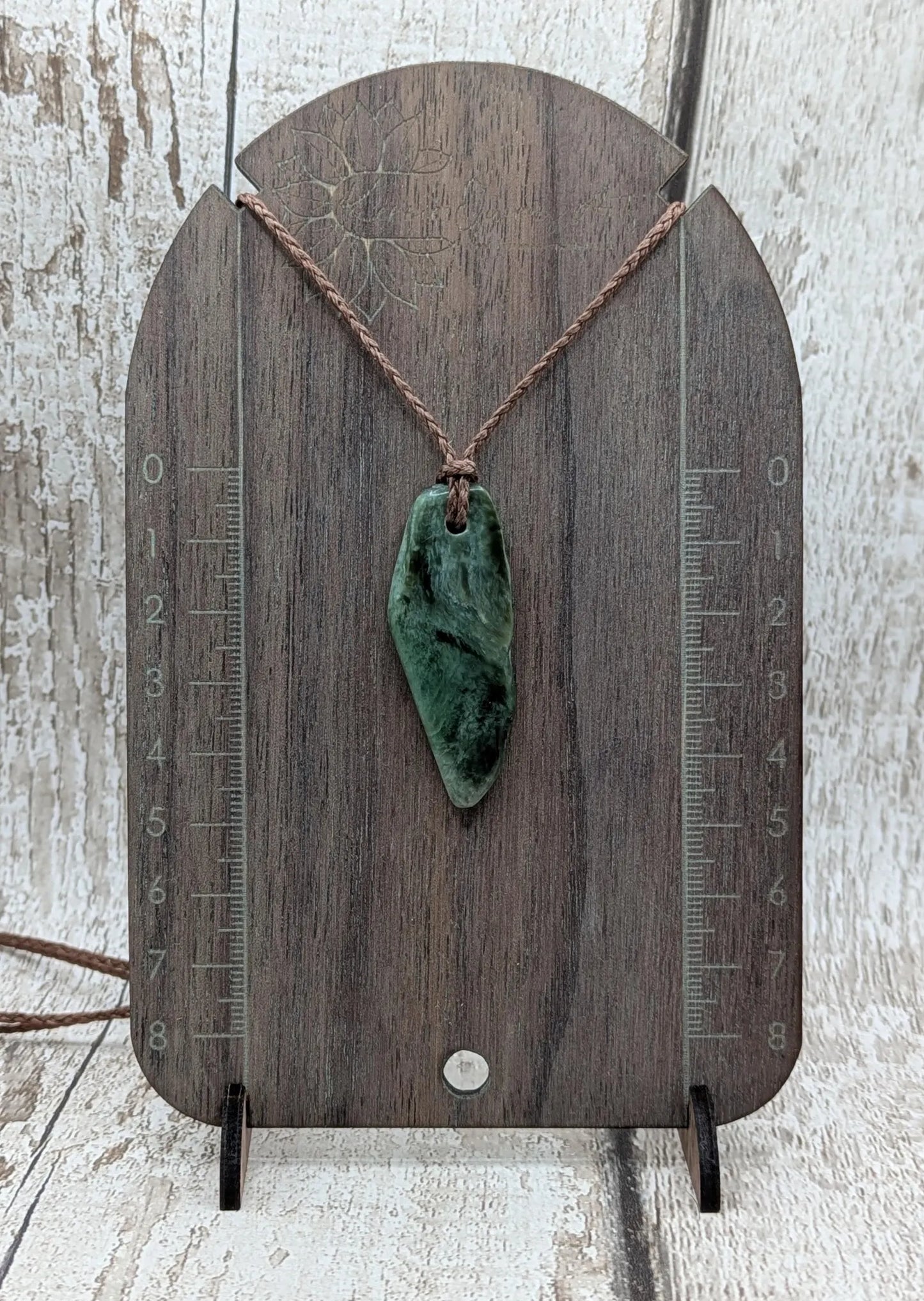 Chatoyant New Zealand tumbled Pounamu greenstone pendant.