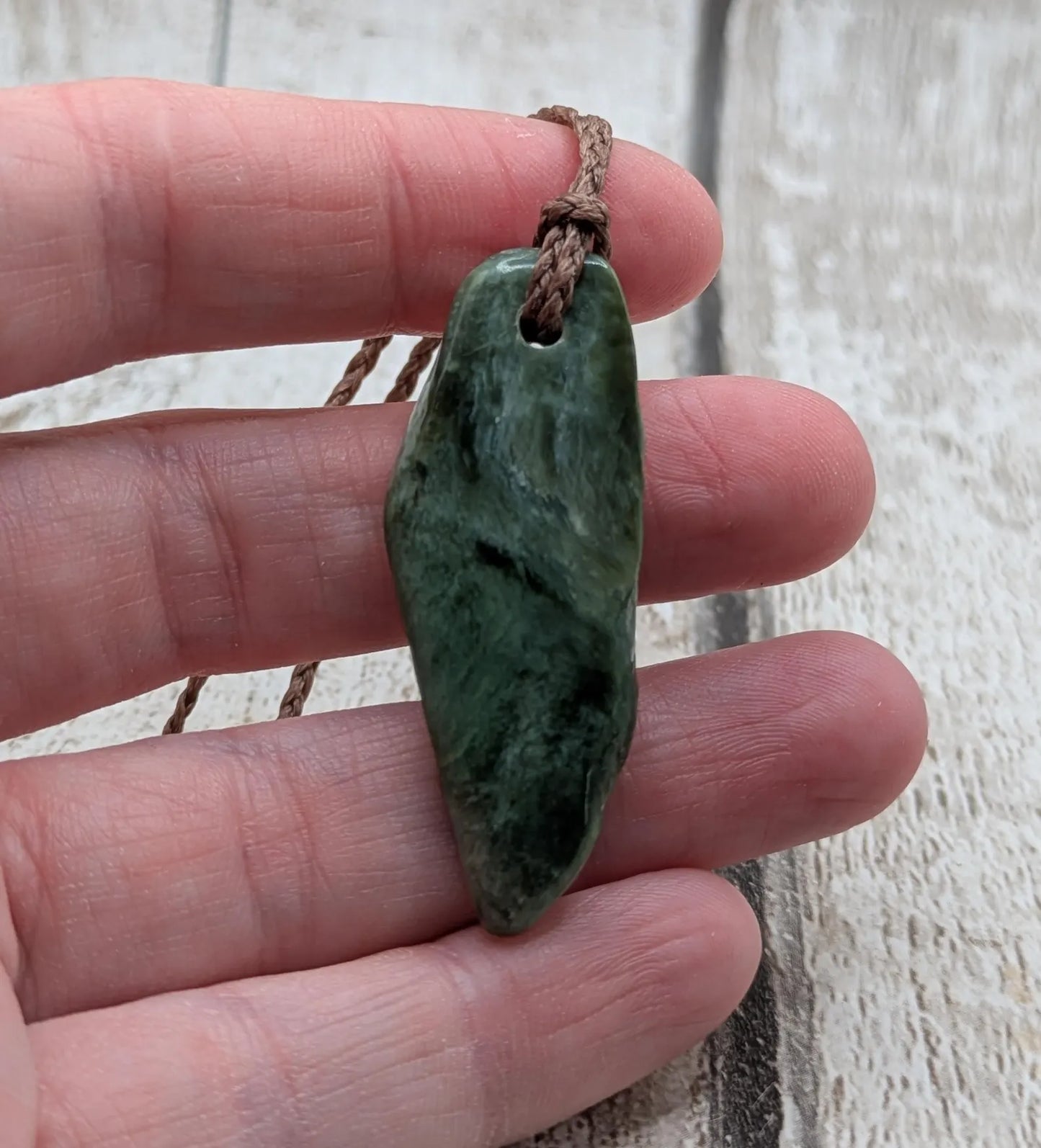 Chatoyant New Zealand tumbled Pounamu greenstone pendant.
