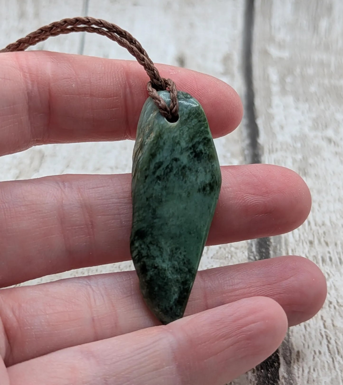 Chatoyant New Zealand tumbled Pounamu greenstone pendant.