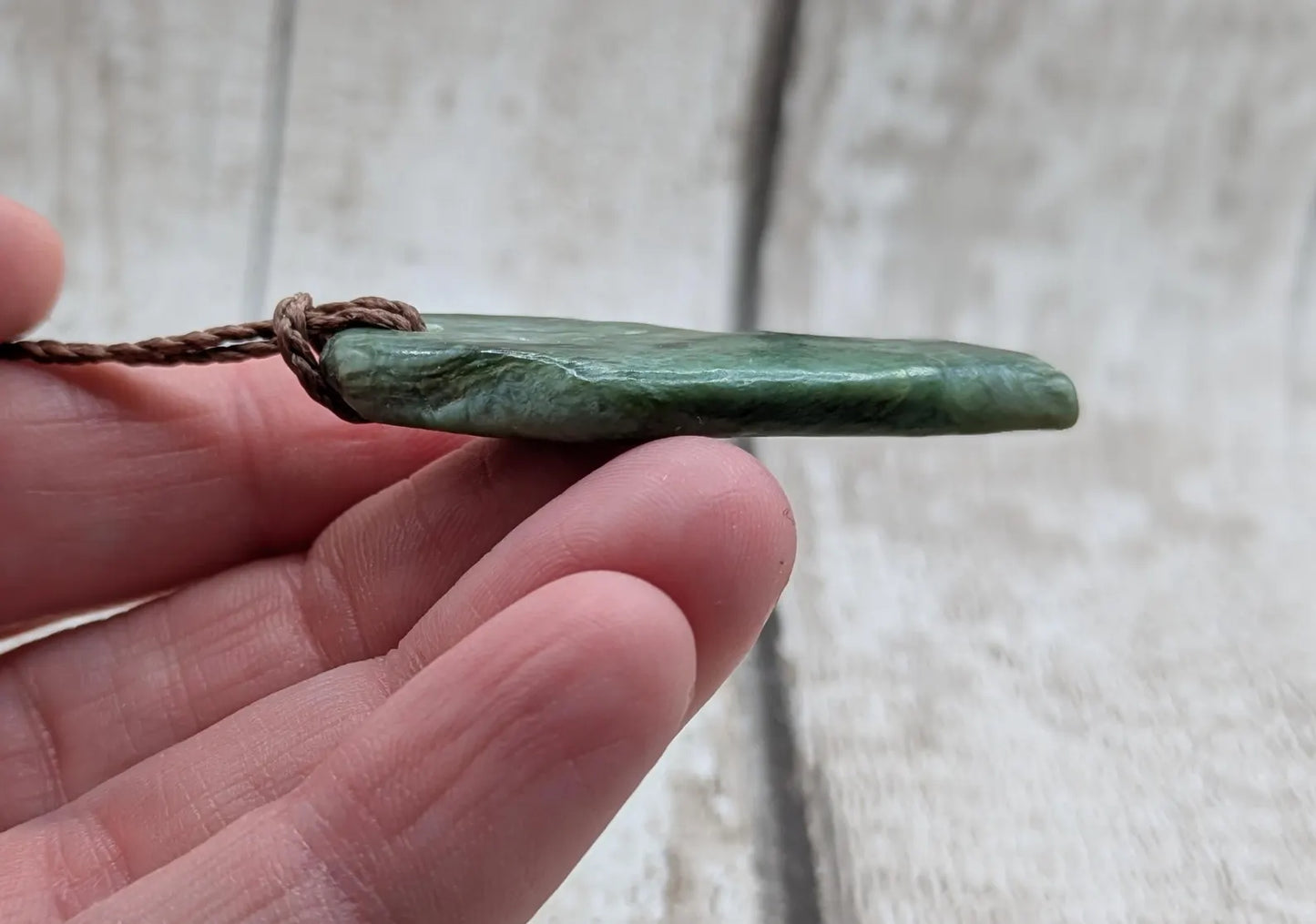 Chatoyant New Zealand tumbled Pounamu greenstone pendant.